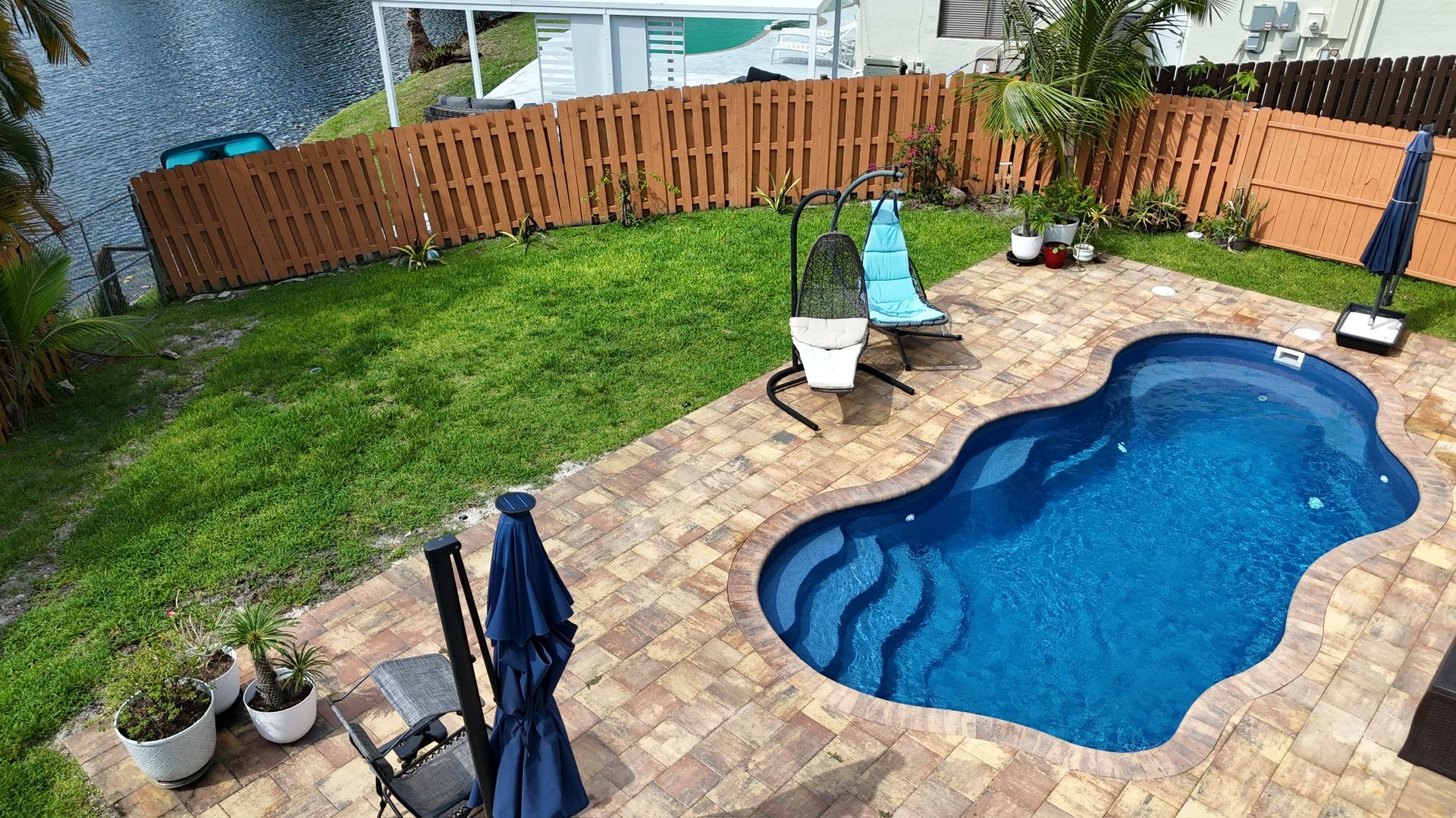 An aerial view of a large swimming pool in a backyard.