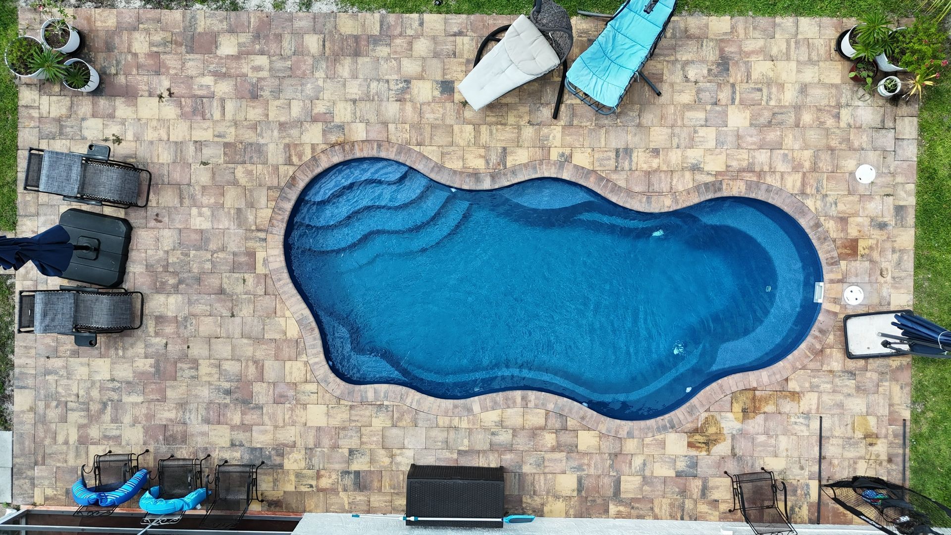 An aerial view of a large swimming pool in a backyard.