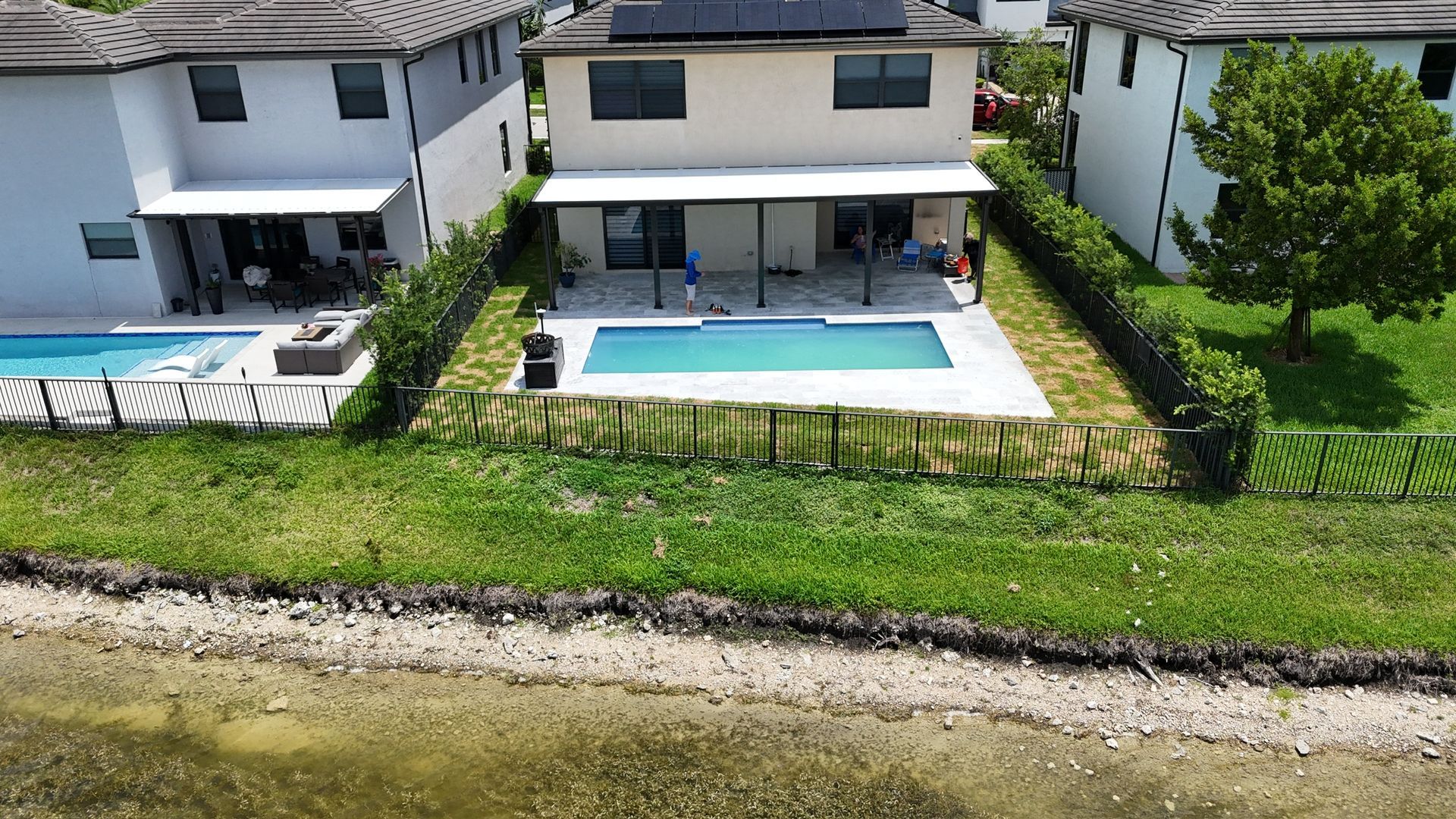 An aerial view of a house with a swimming pool in the backyard.
