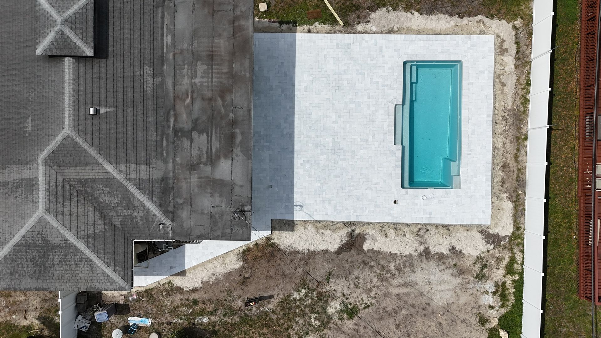 An aerial view of a house with a pool in the backyard.