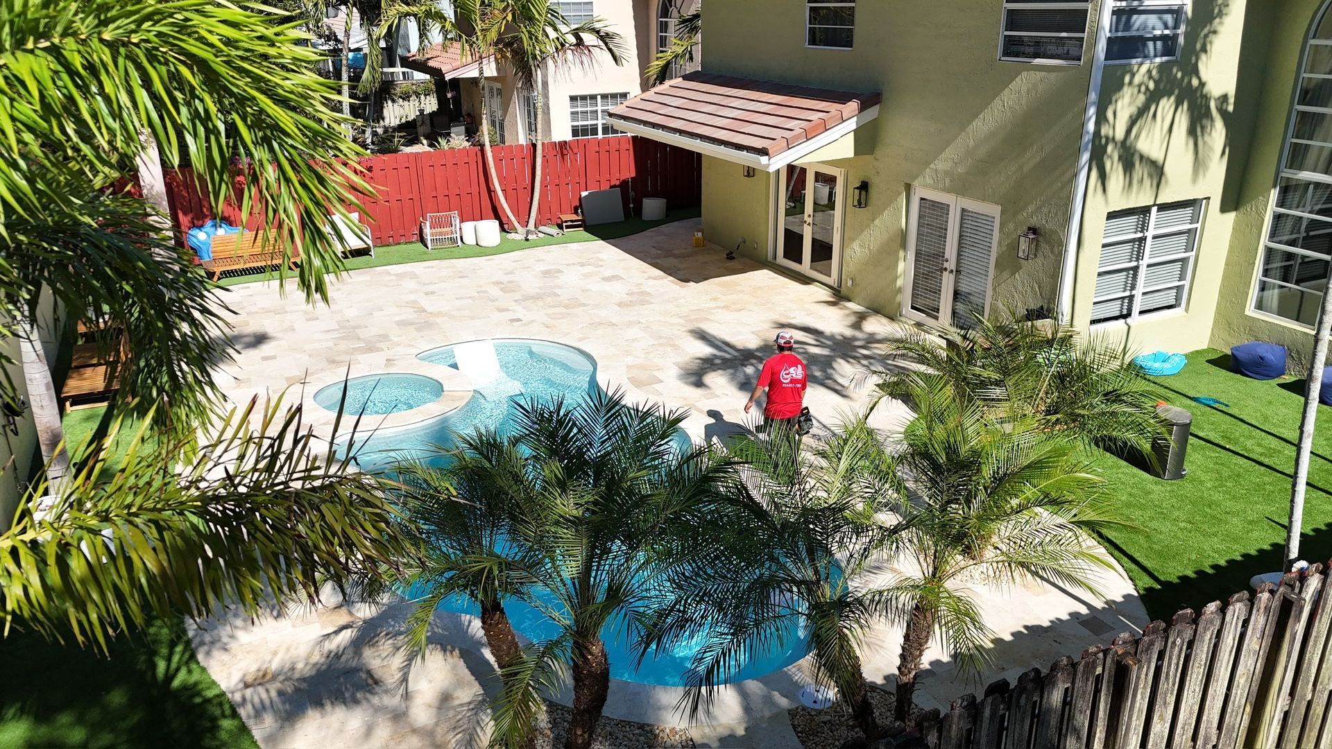 An aerial view of a house with a swimming pool in the backyard.
