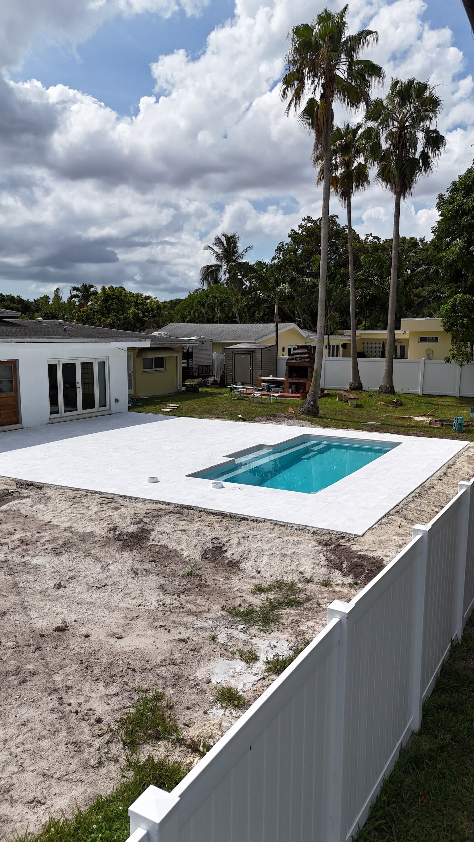 A swimming pool is being built in the backyard of a house.