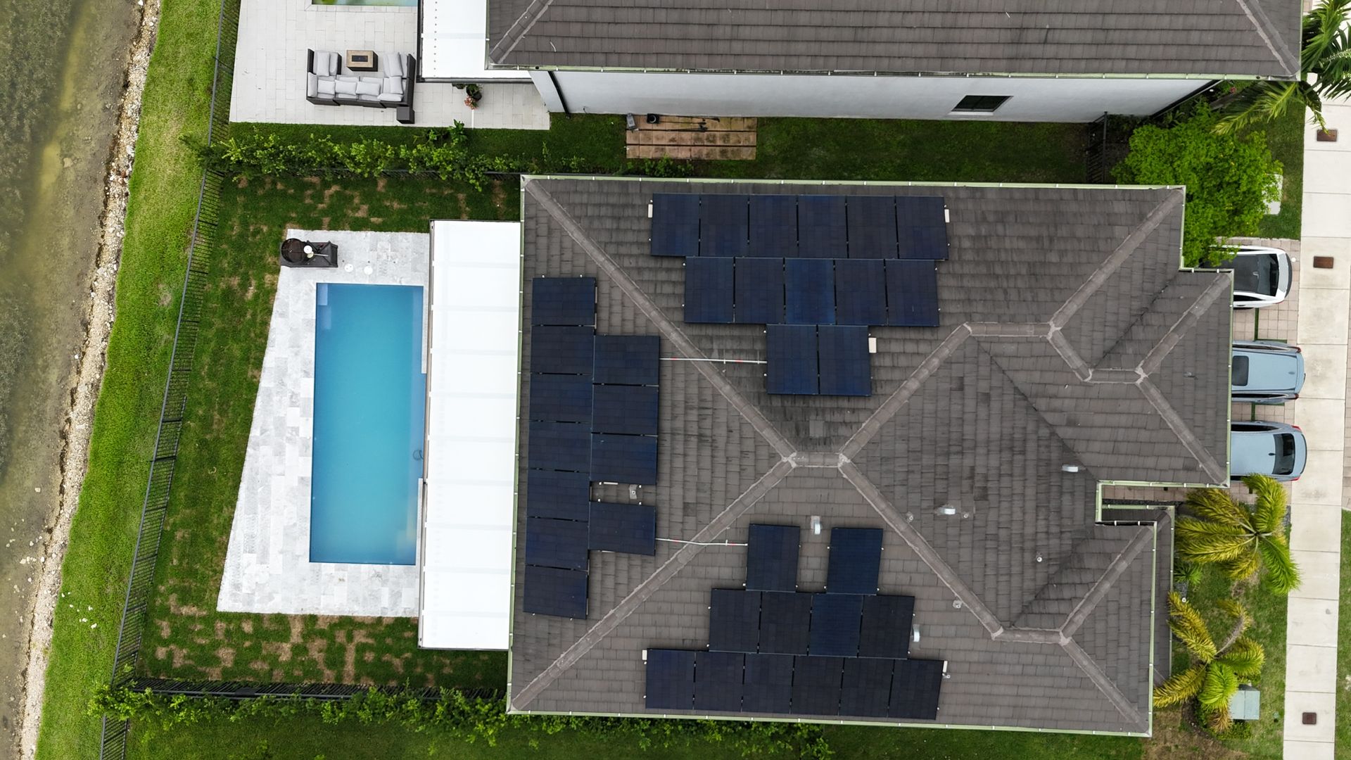 An aerial view of a house with a pool and solar panels on the roof.