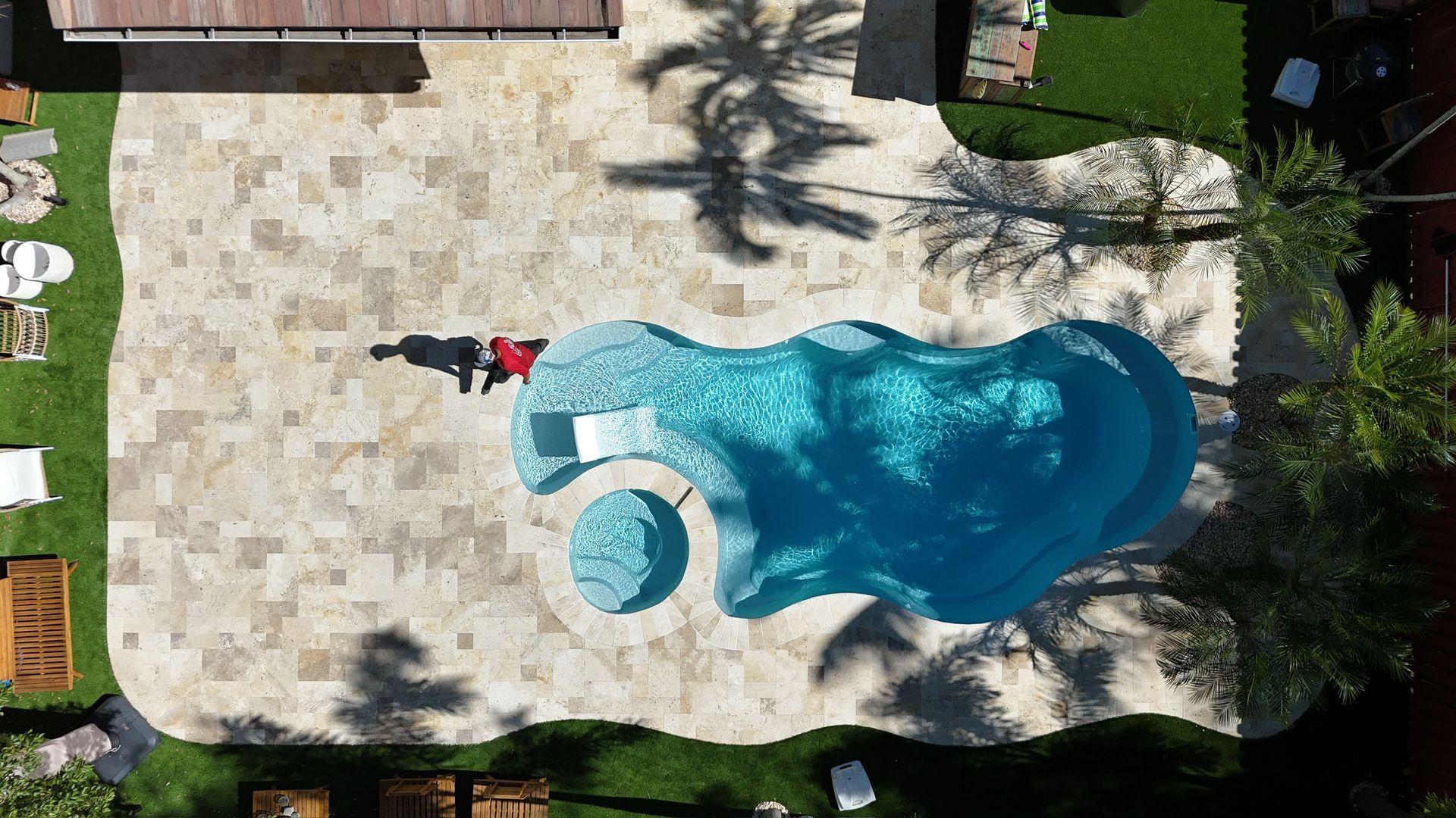An aerial view of a large swimming pool in a backyard.