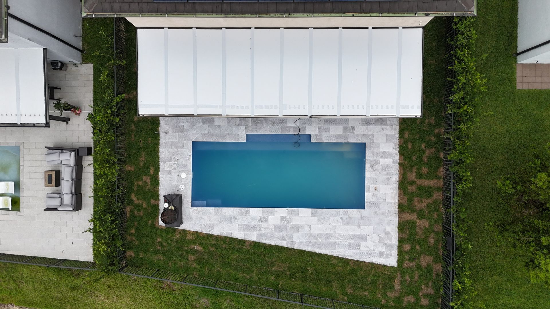 An aerial view of a large swimming pool in a backyard.