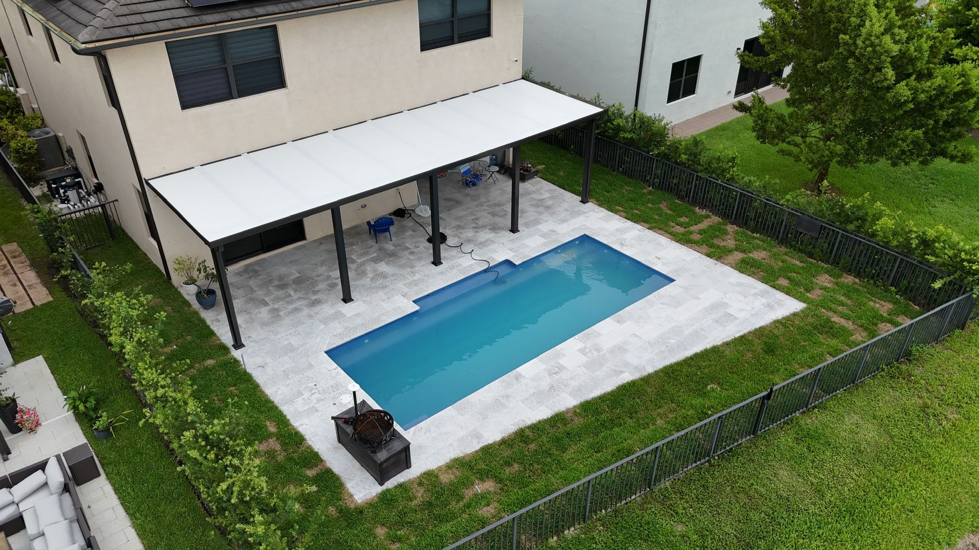 An aerial view of a house with a swimming pool in the backyard.