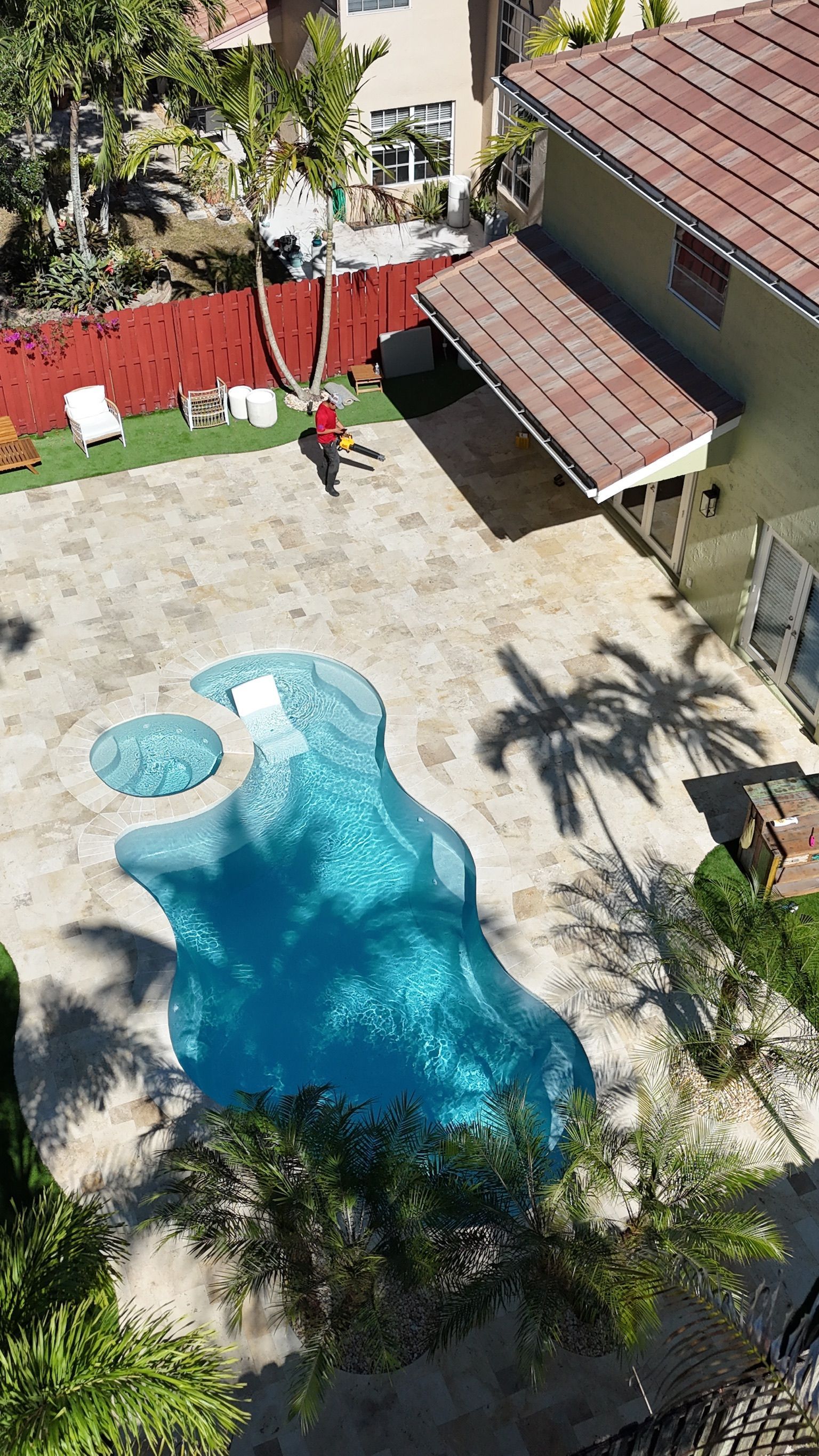 An aerial view of a swimming pool in the backyard of a house.