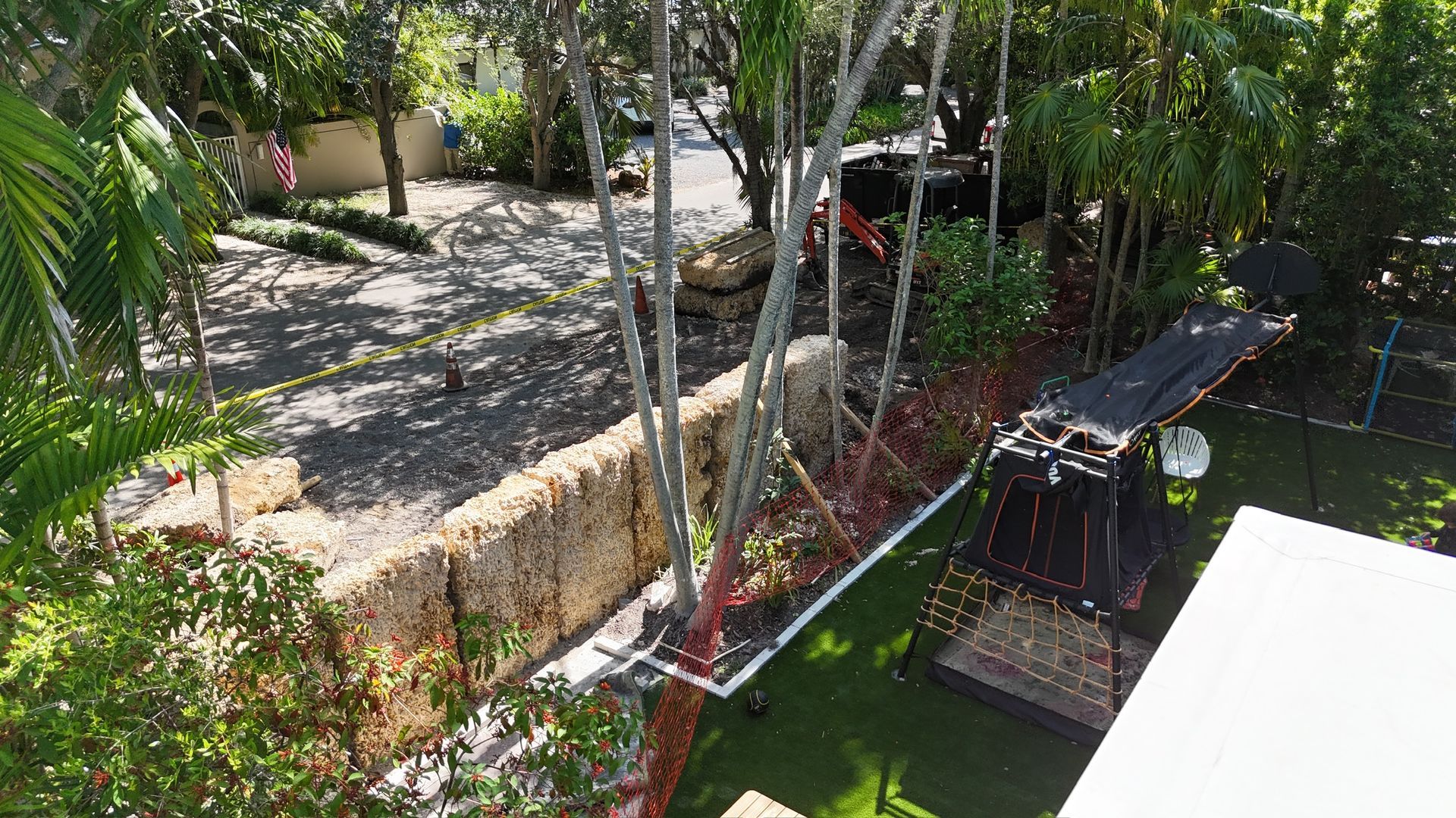An aerial view of a backyard with trees and scaffolding.