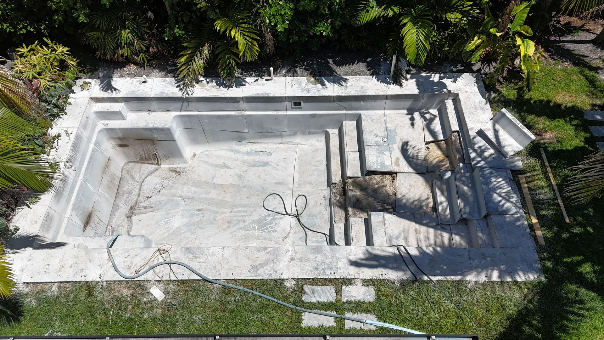 An aerial view of a swimming pool being built in a backyard.