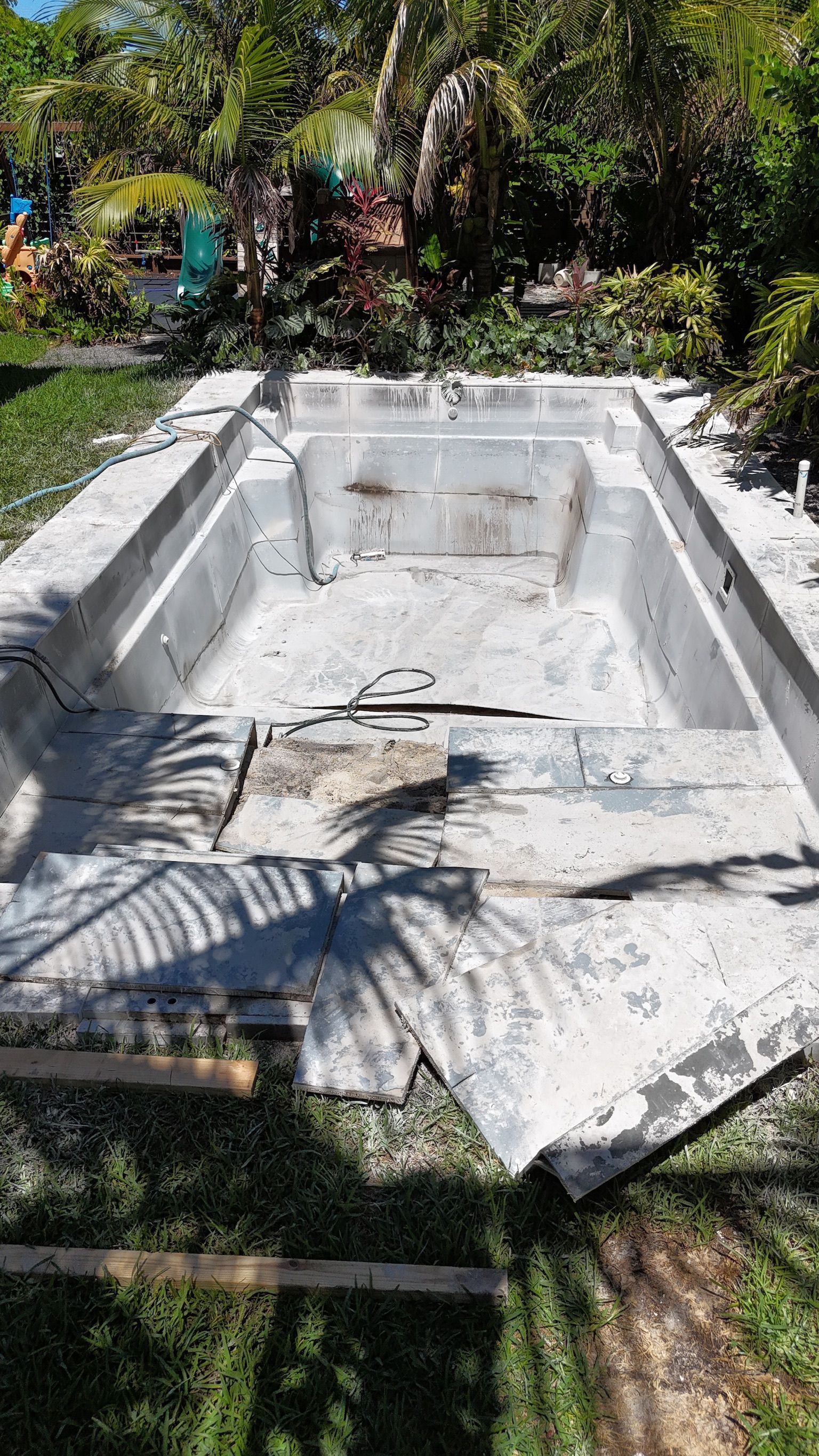 A swimming pool is being built in a backyard.