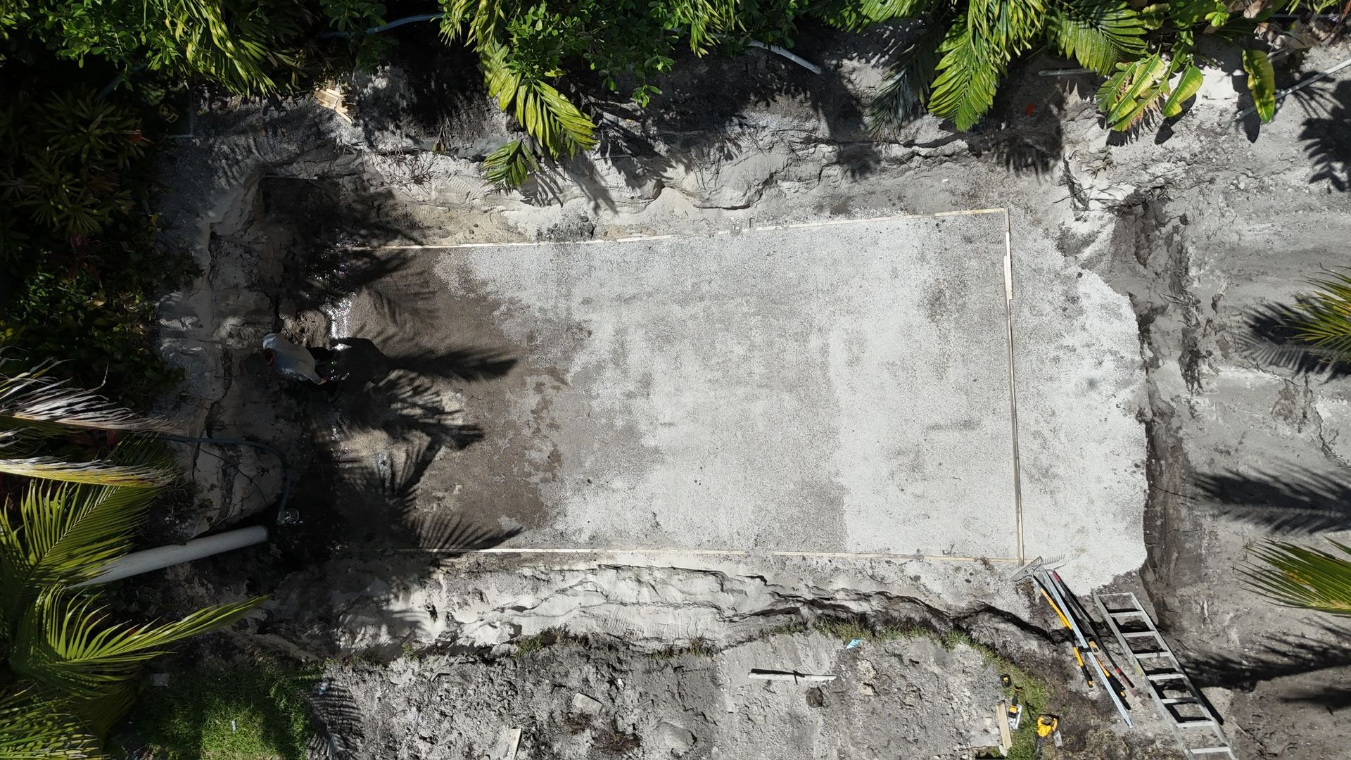 An aerial view of a concrete wall surrounded by trees.