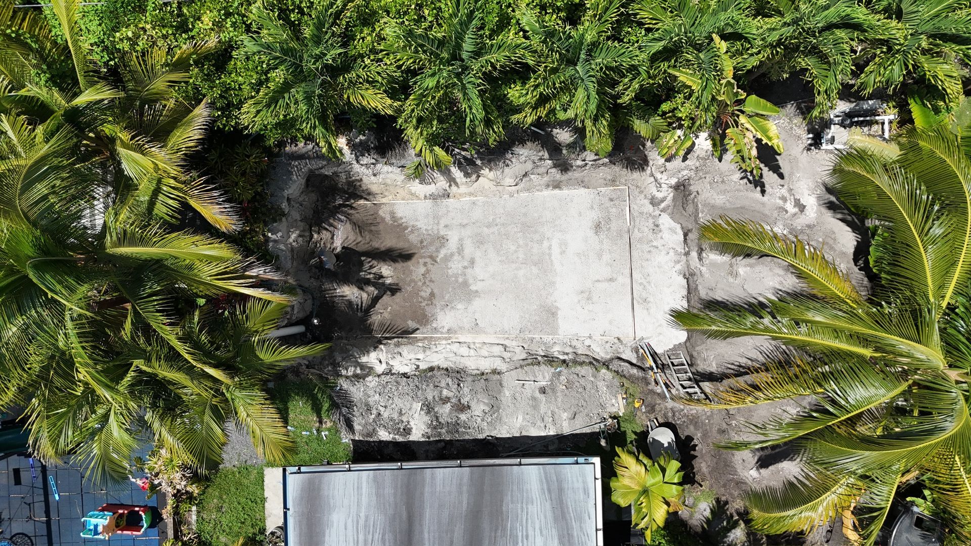 An aerial view of a house surrounded by palm trees.
