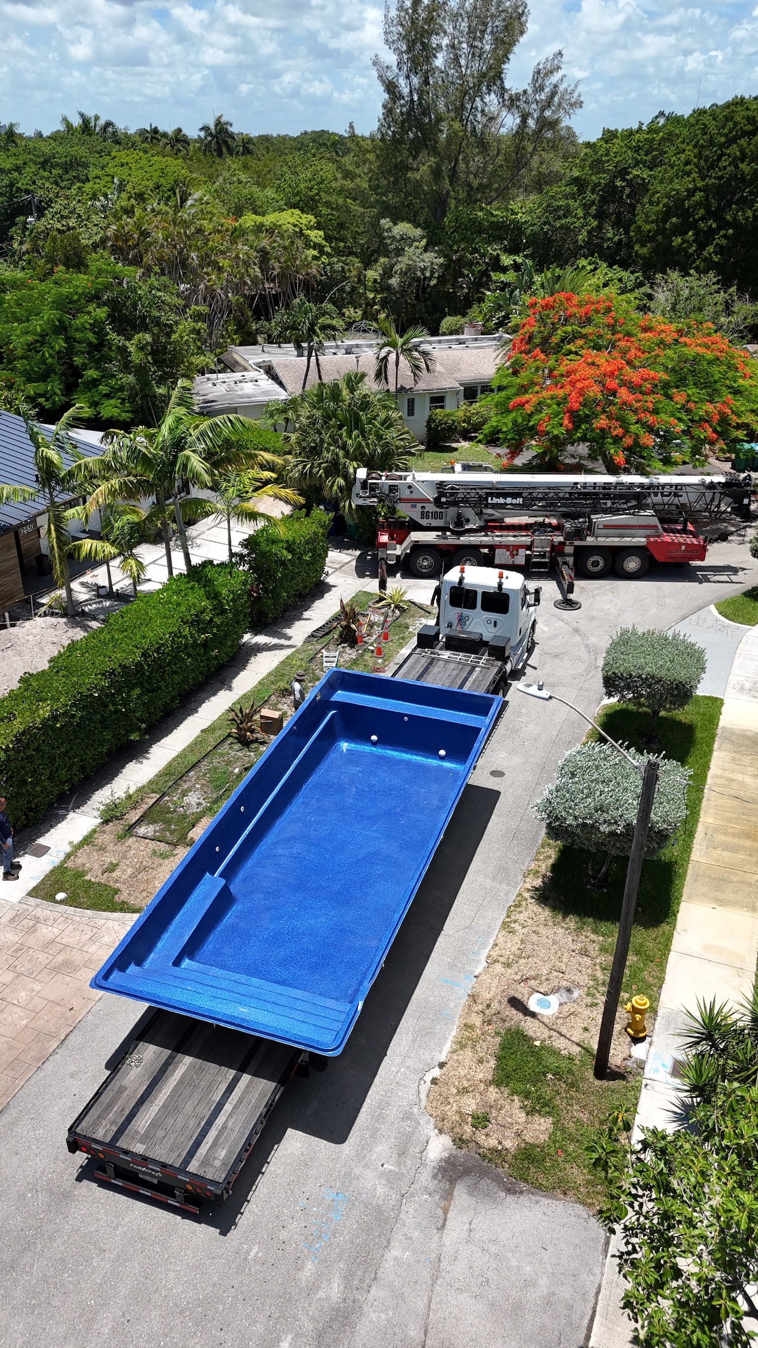 An aerial view of a truck carrying a large blue swimming pool.
