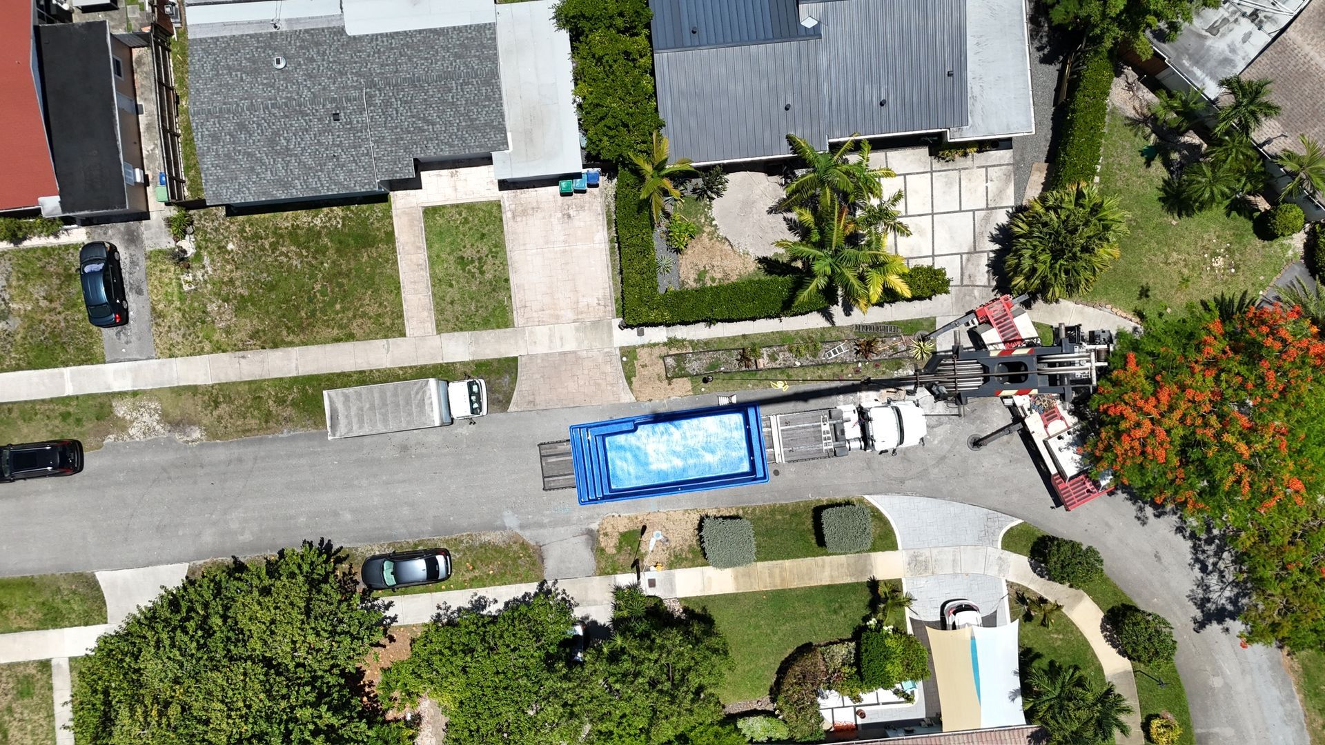 An aerial view of a residential neighborhood with a blue container on a trailer.
