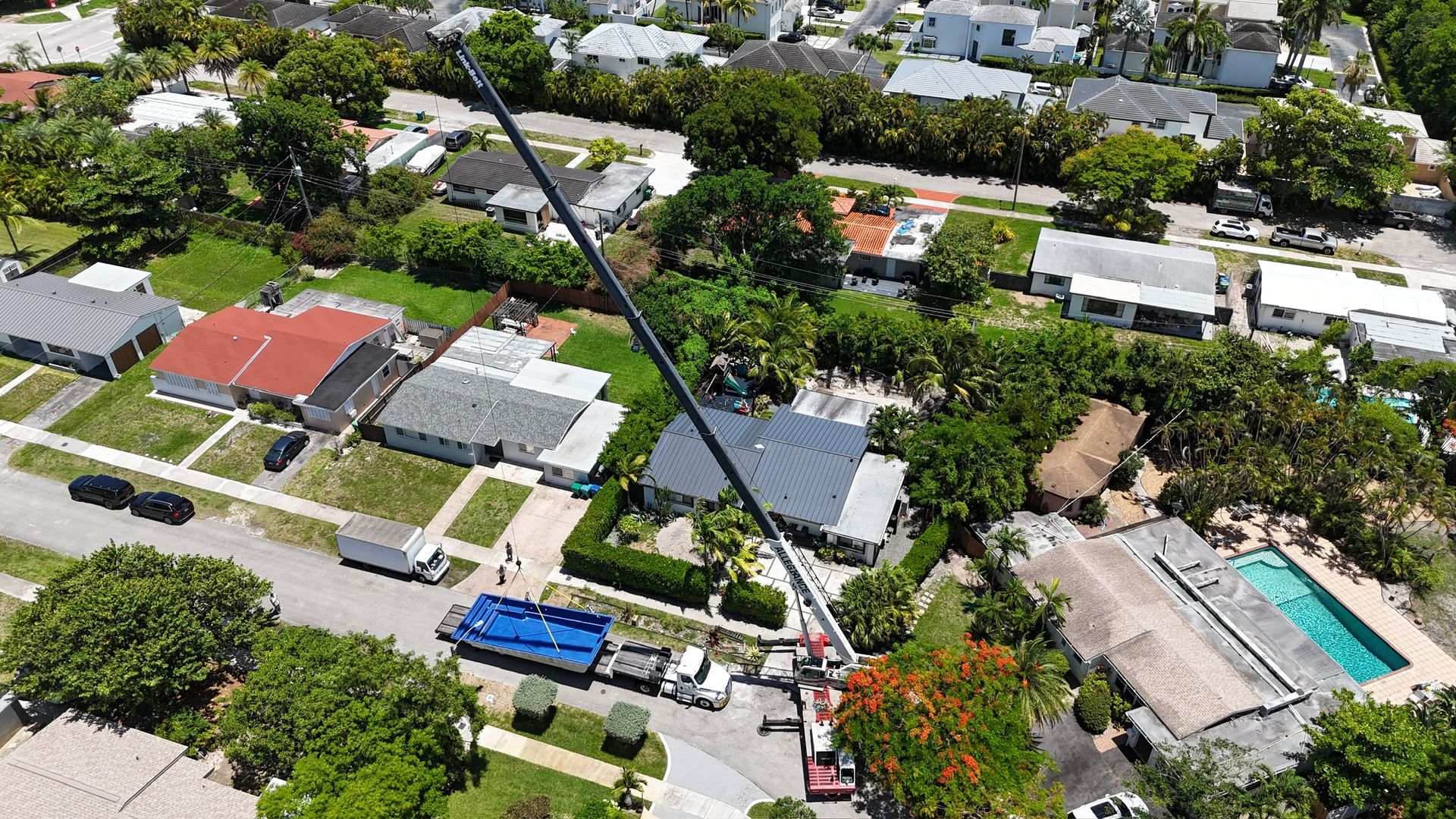 An aerial view of a residential area with a crane in the middle of it.