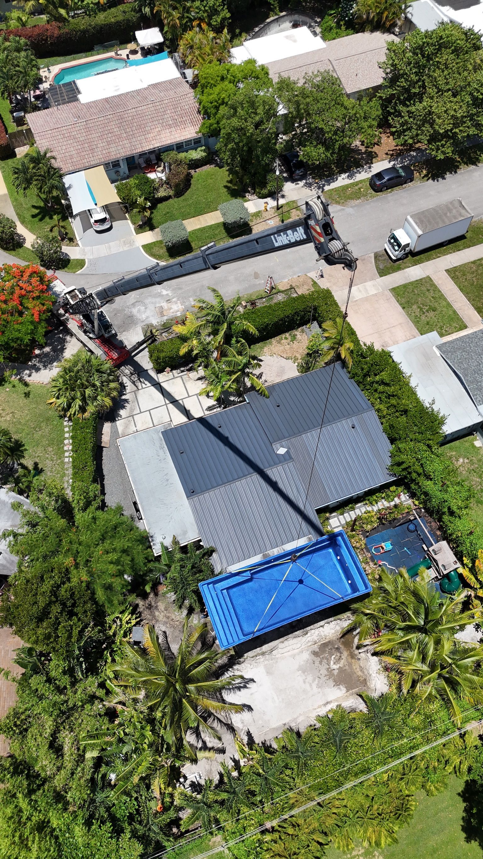 An aerial view of a residential area with a blue container in the middle of the yard.