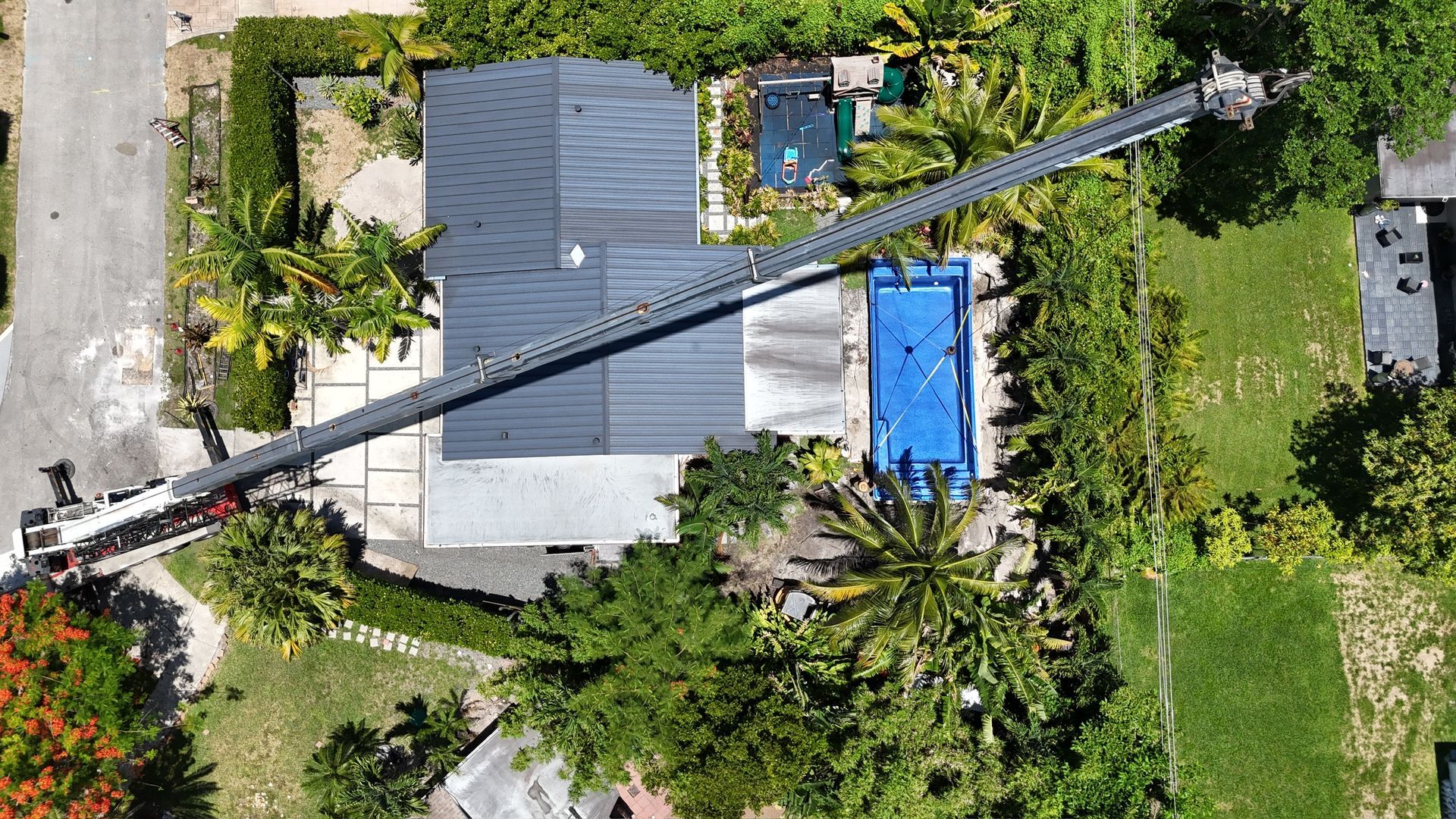 An aerial view of a house with a pool and a crane.