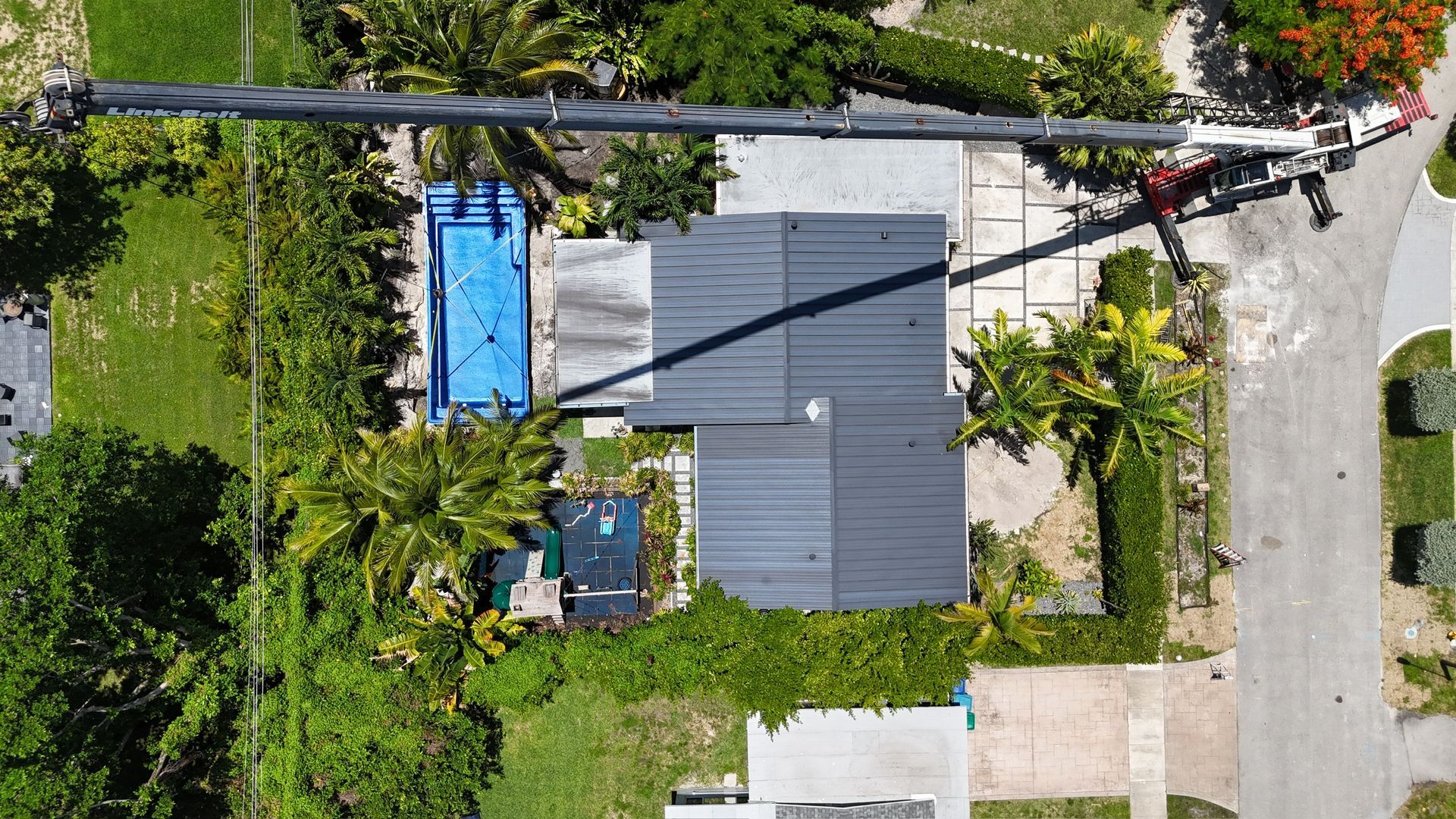 An aerial view of a house with a pool and a crane.