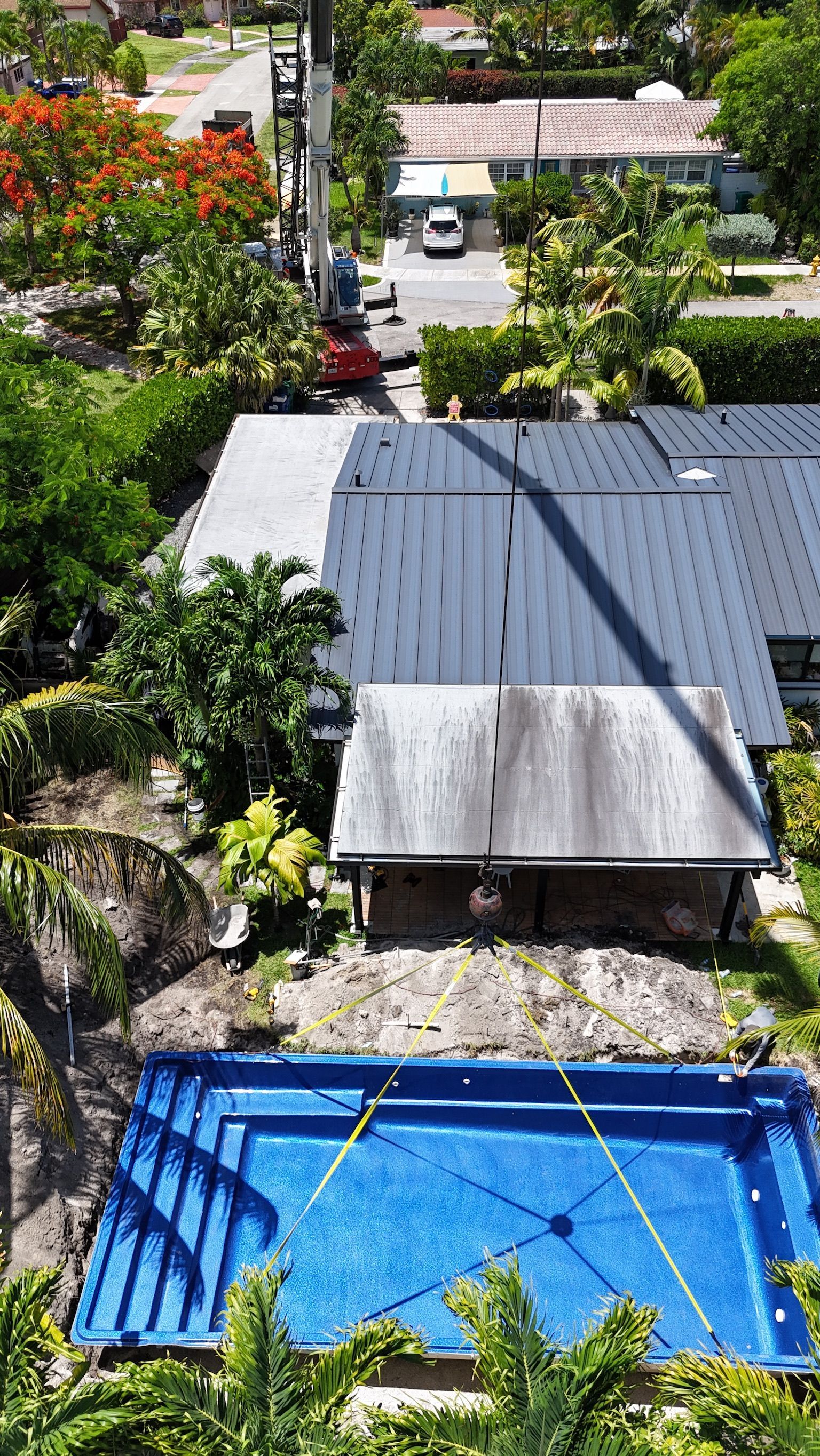An aerial view of a house with a swimming pool in front of it.