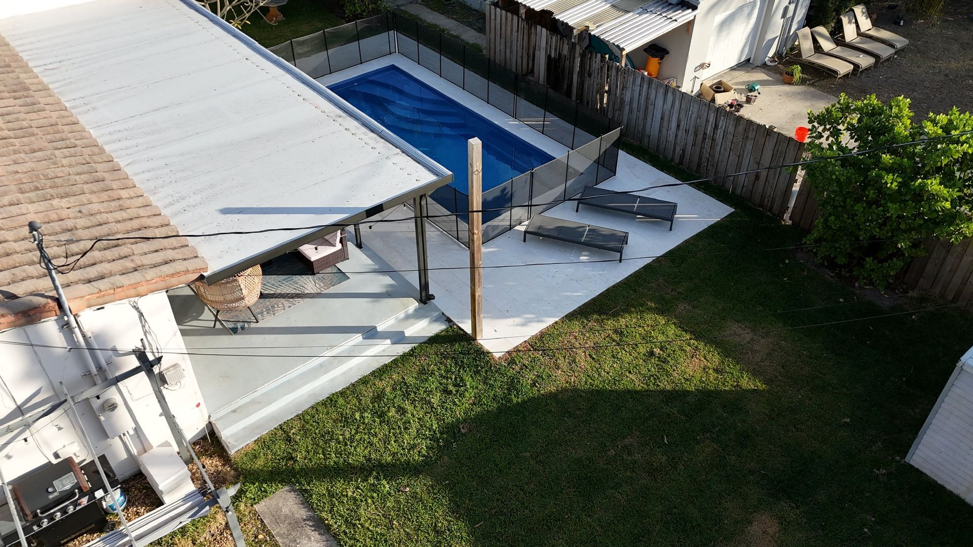 An aerial view of a house with a swimming pool in the backyard.
