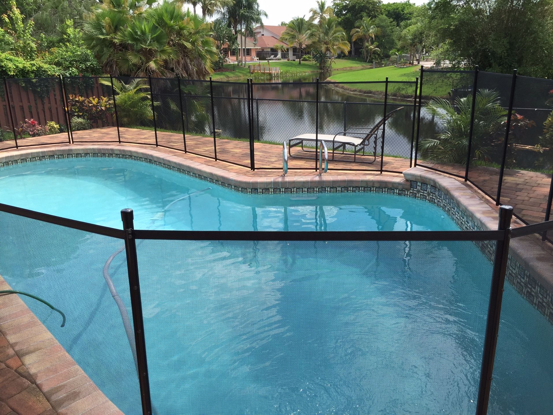 A large swimming pool with a black fence around it.