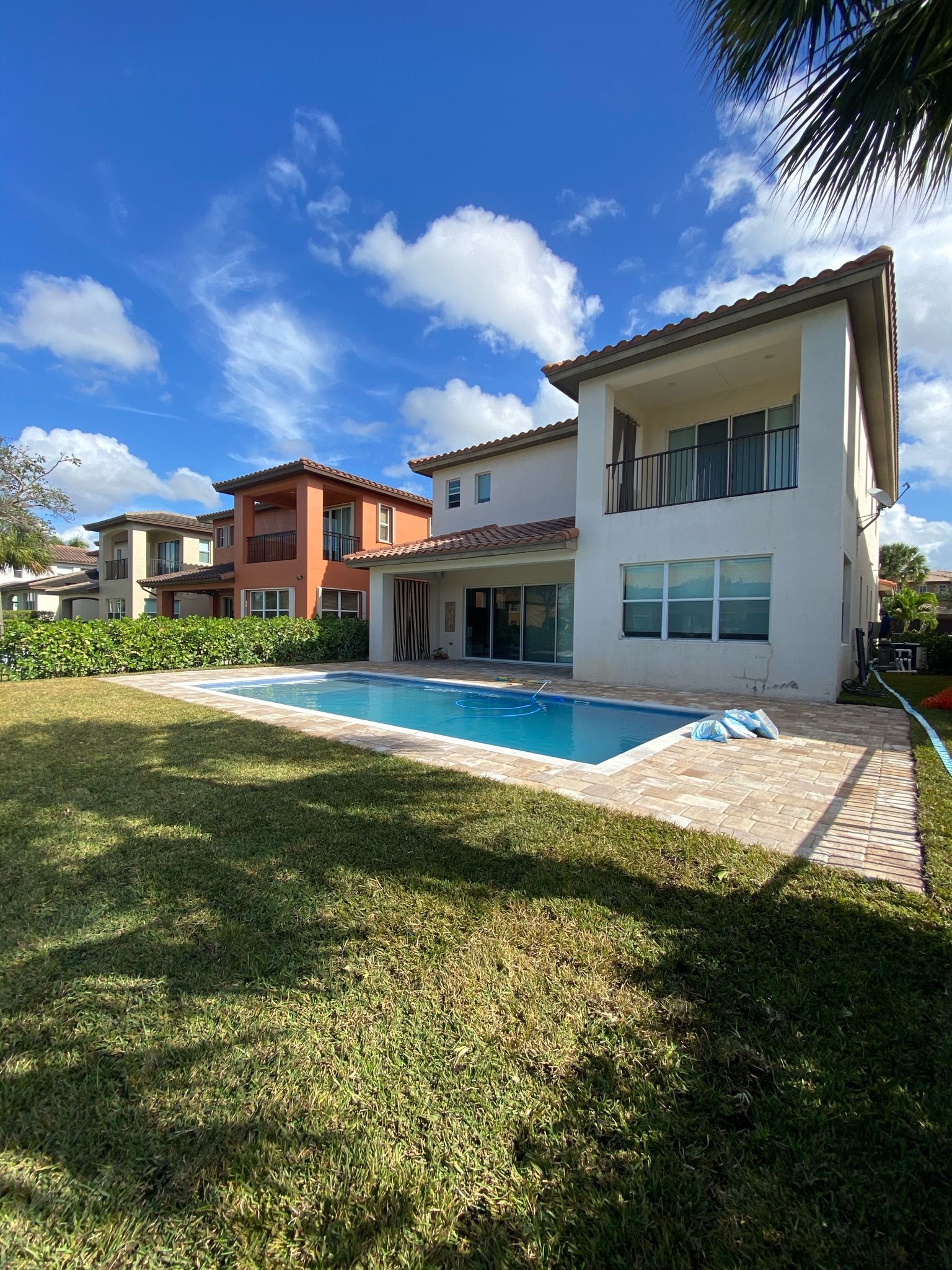 A large white house with a large swimming pool in the backyard.