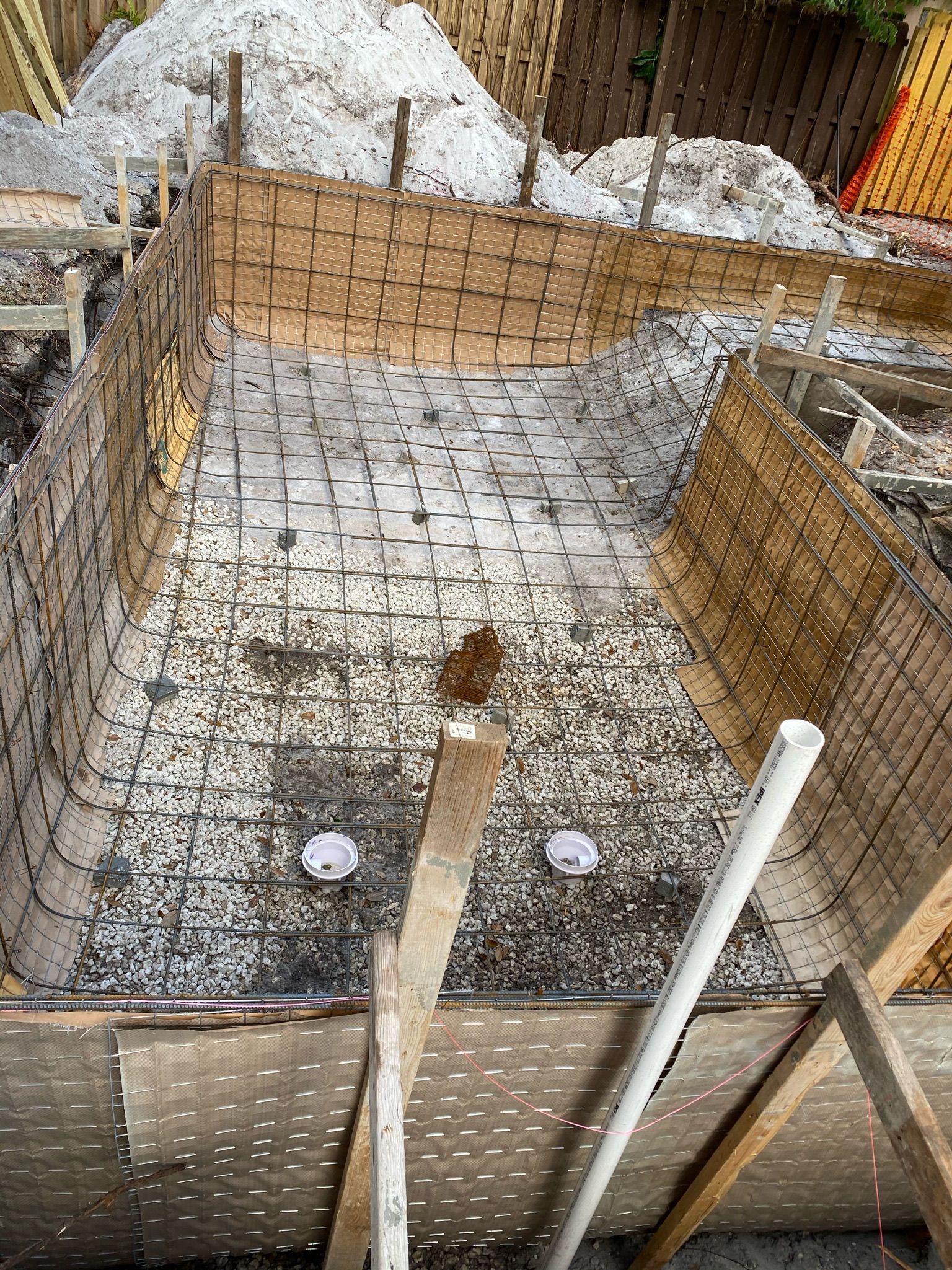 A swimming pool is being built in a backyard.