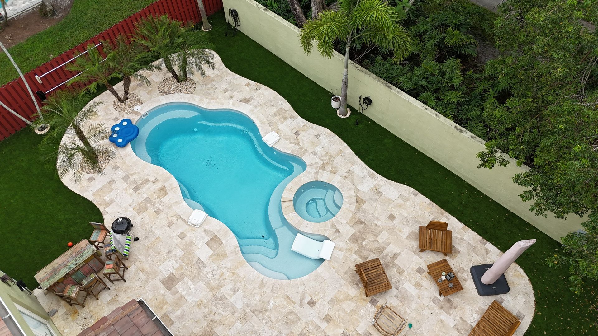 An aerial view of a large swimming pool in a backyard.