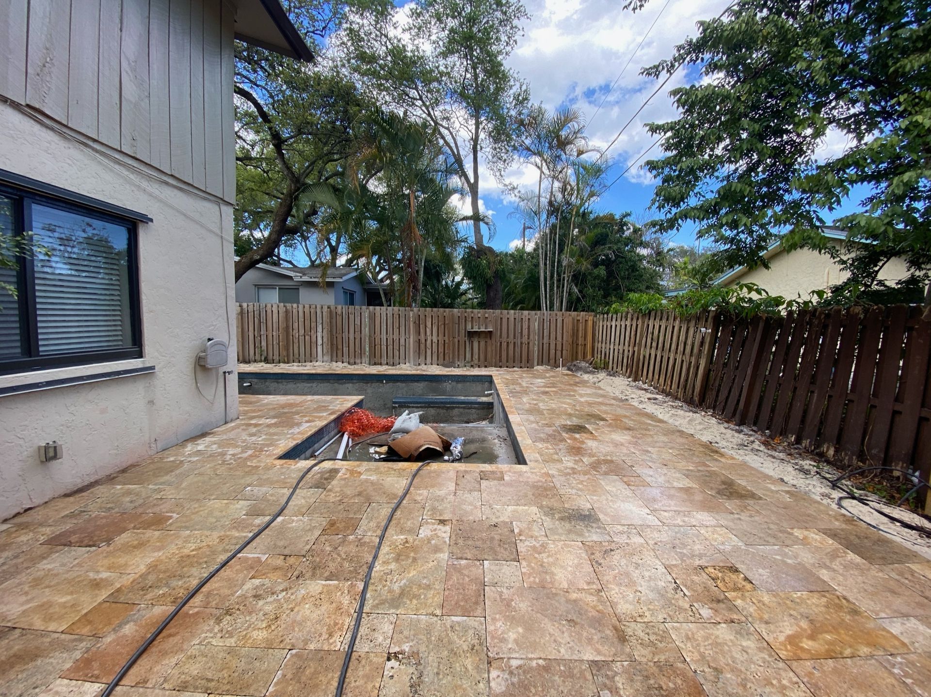 There is a swimming pool in the backyard of a house.