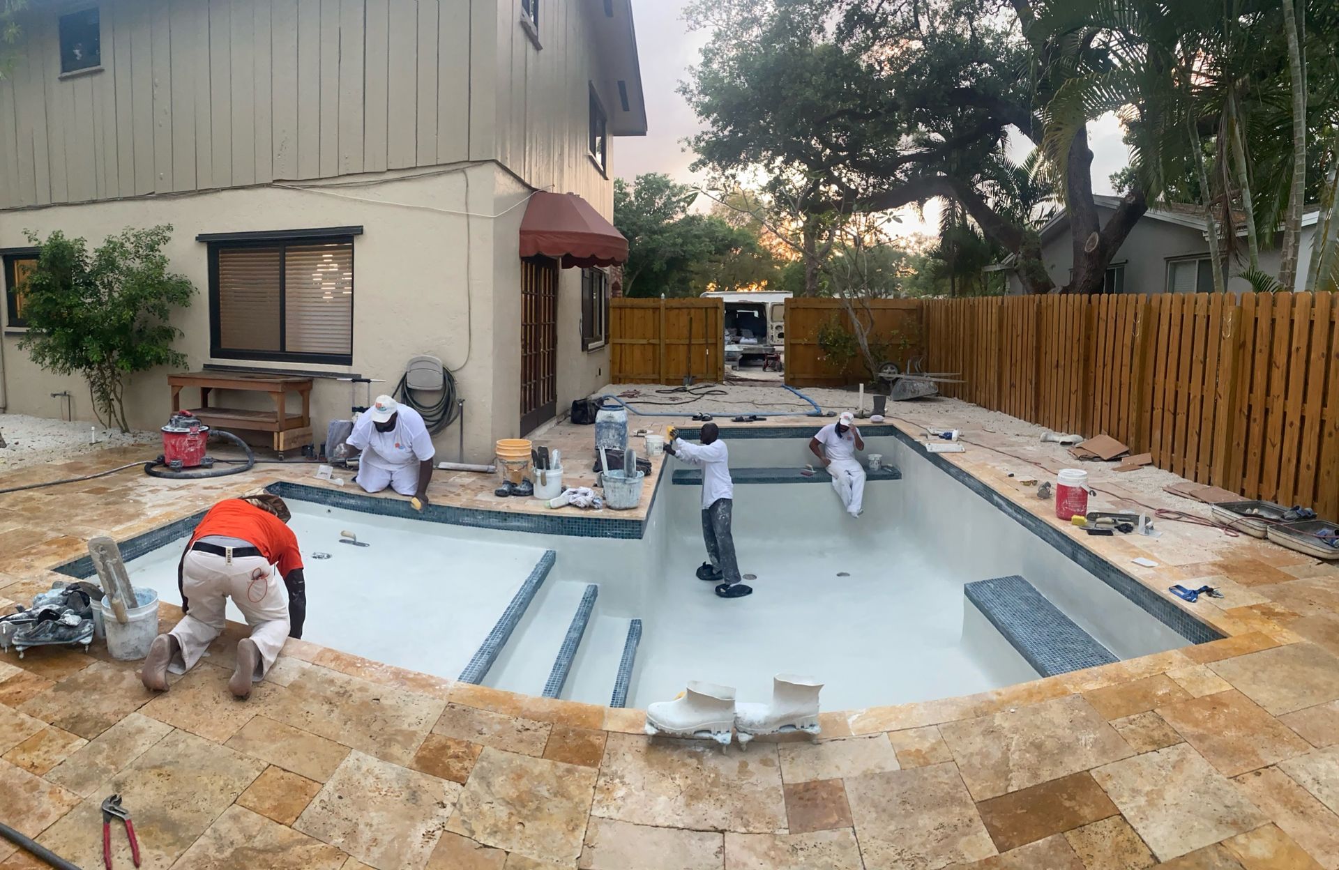 A swimming pool is being built in the backyard of a house