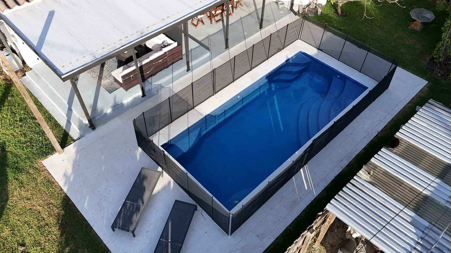 An aerial view of a large swimming pool surrounded by a fence