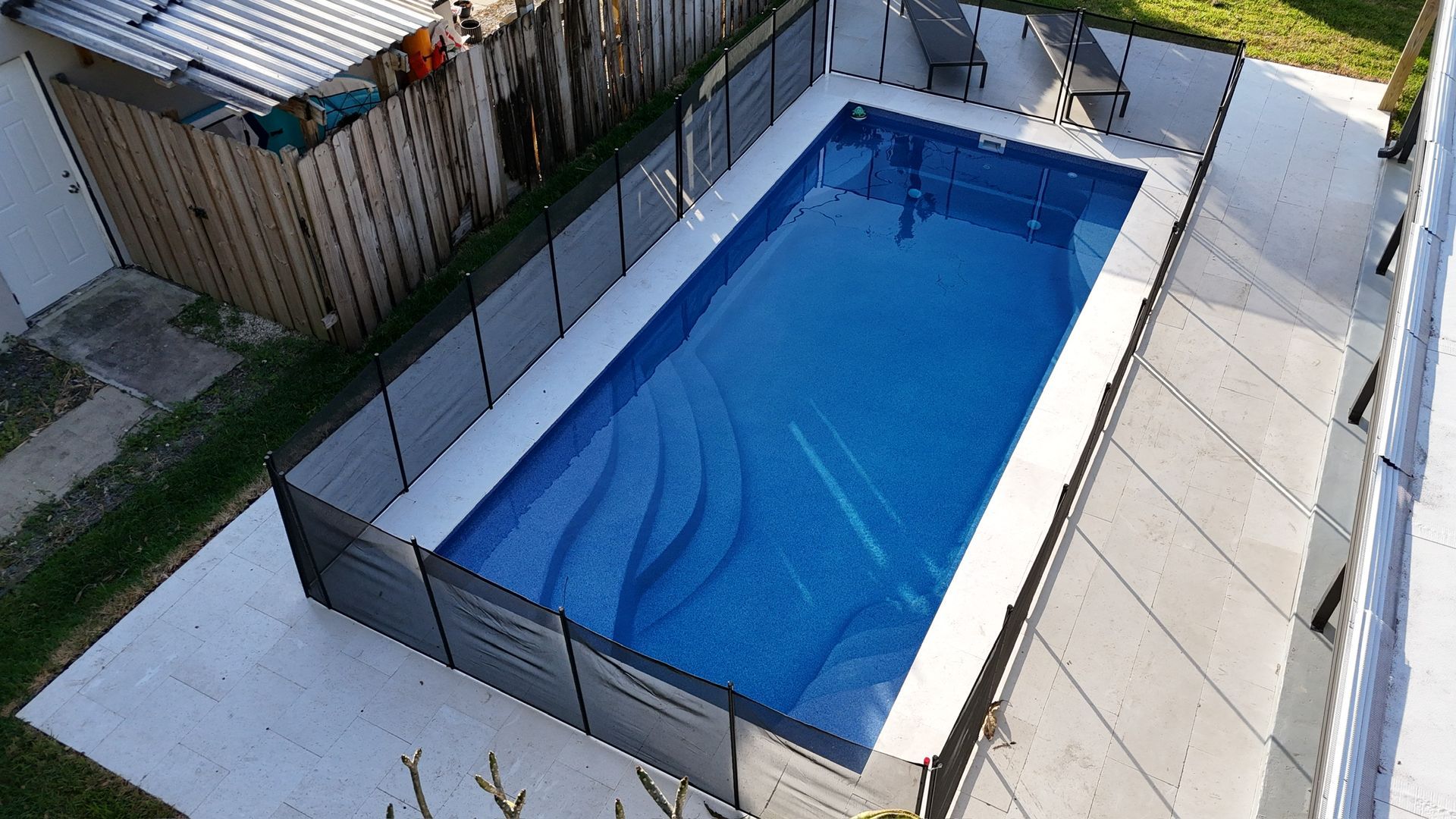 An aerial view of a swimming pool surrounded by a fence