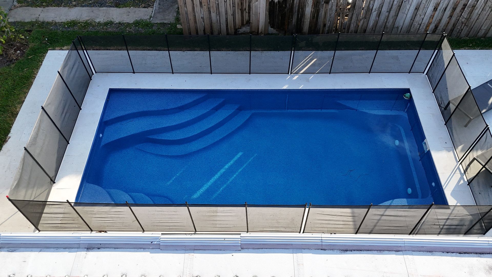 An aerial view of a swimming pool with a fence around it