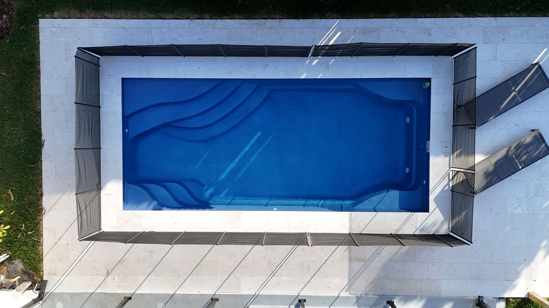 An aerial view of a swimming pool with a fence around it