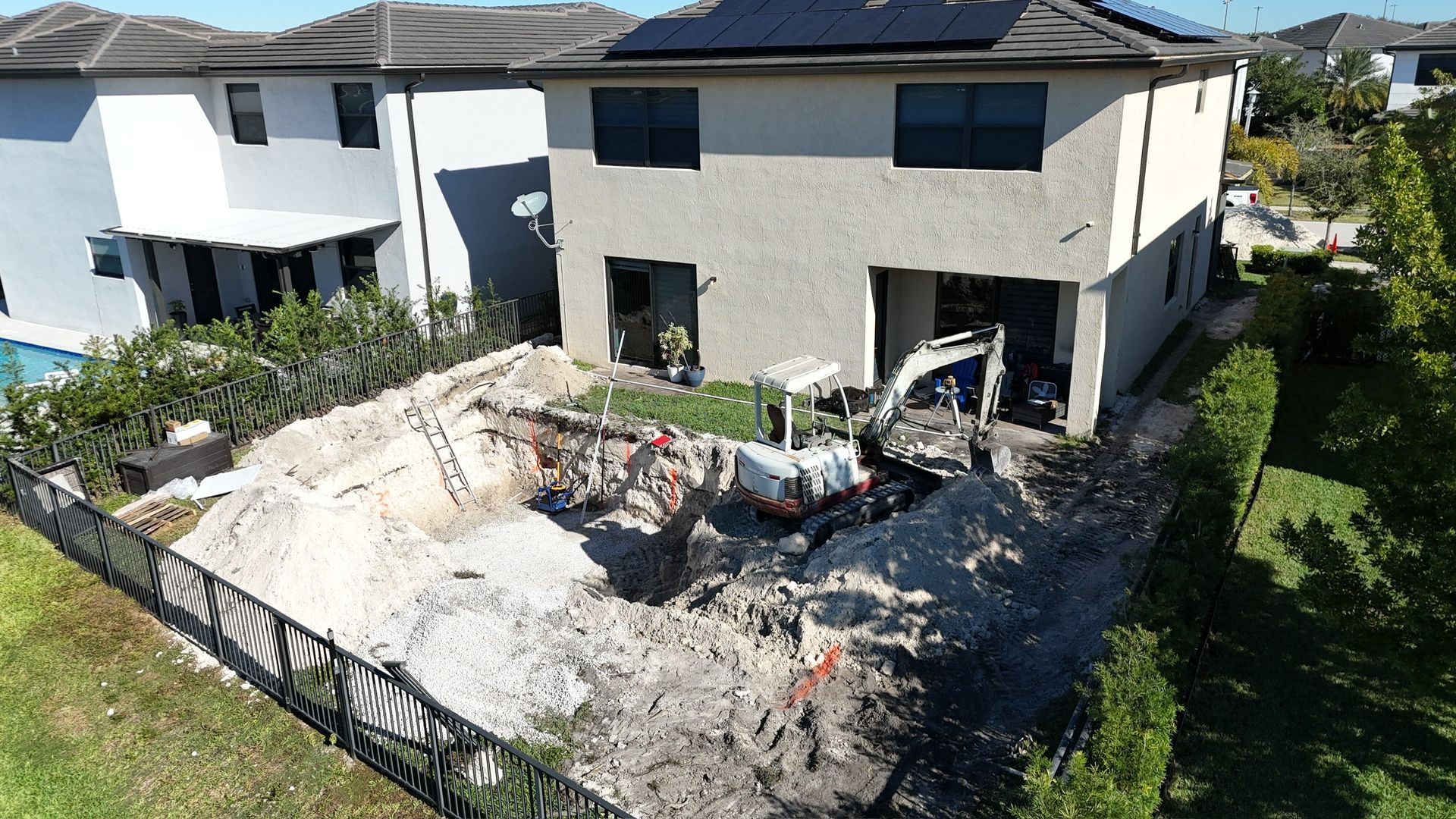 An aerial view of a house with a hole in the ground in front of it