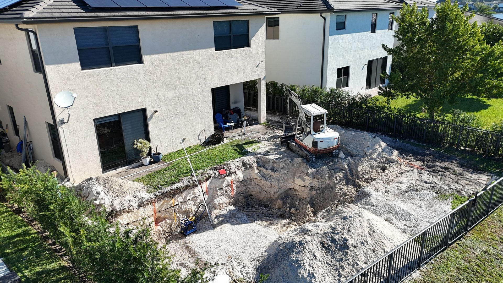 An aerial view of a construction site in front of a house.