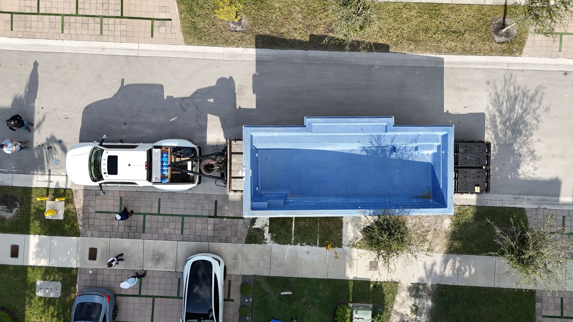 An aerial view of a truck and a swimming pool in a driveway.