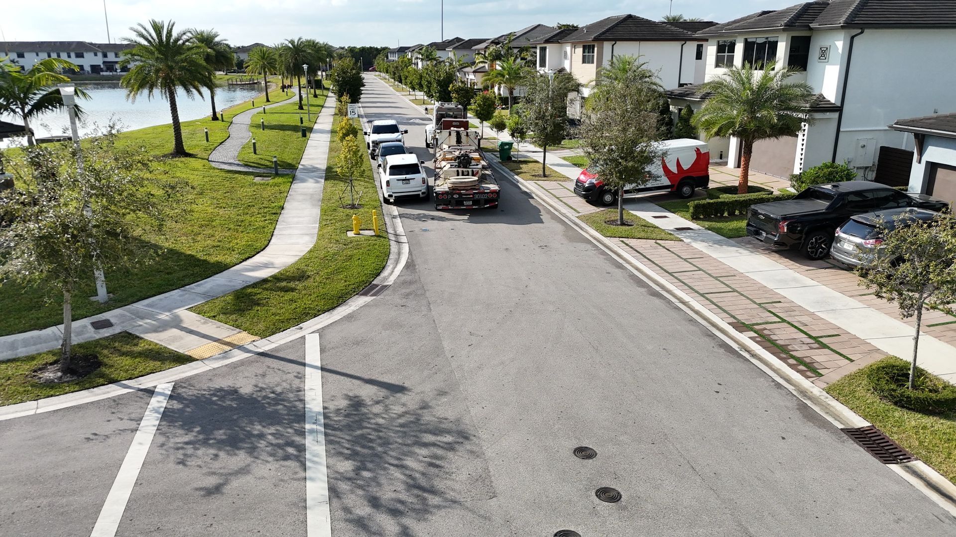 An aerial view of a residential street with a tow truck parked on the side of the road.