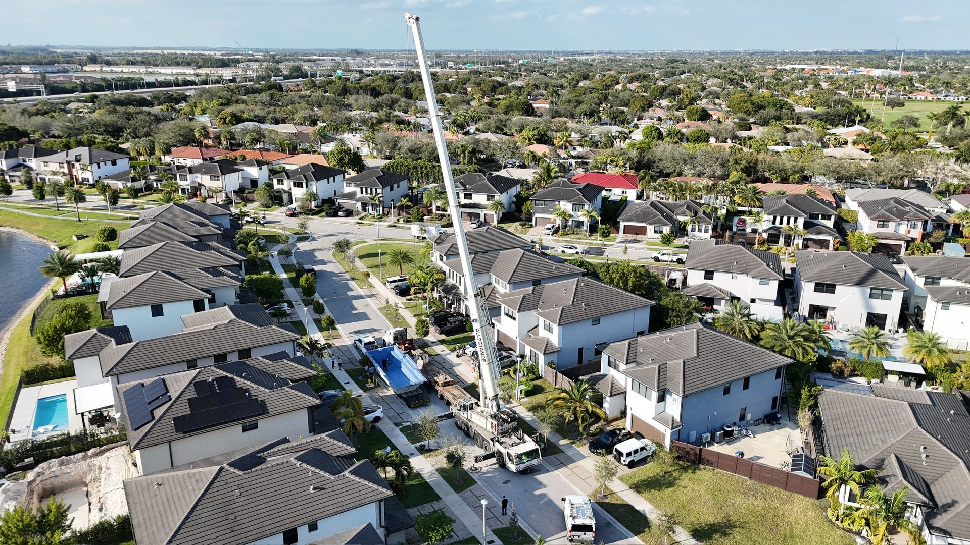 An aerial view of a residential neighborhood with a crane in the middle of it.