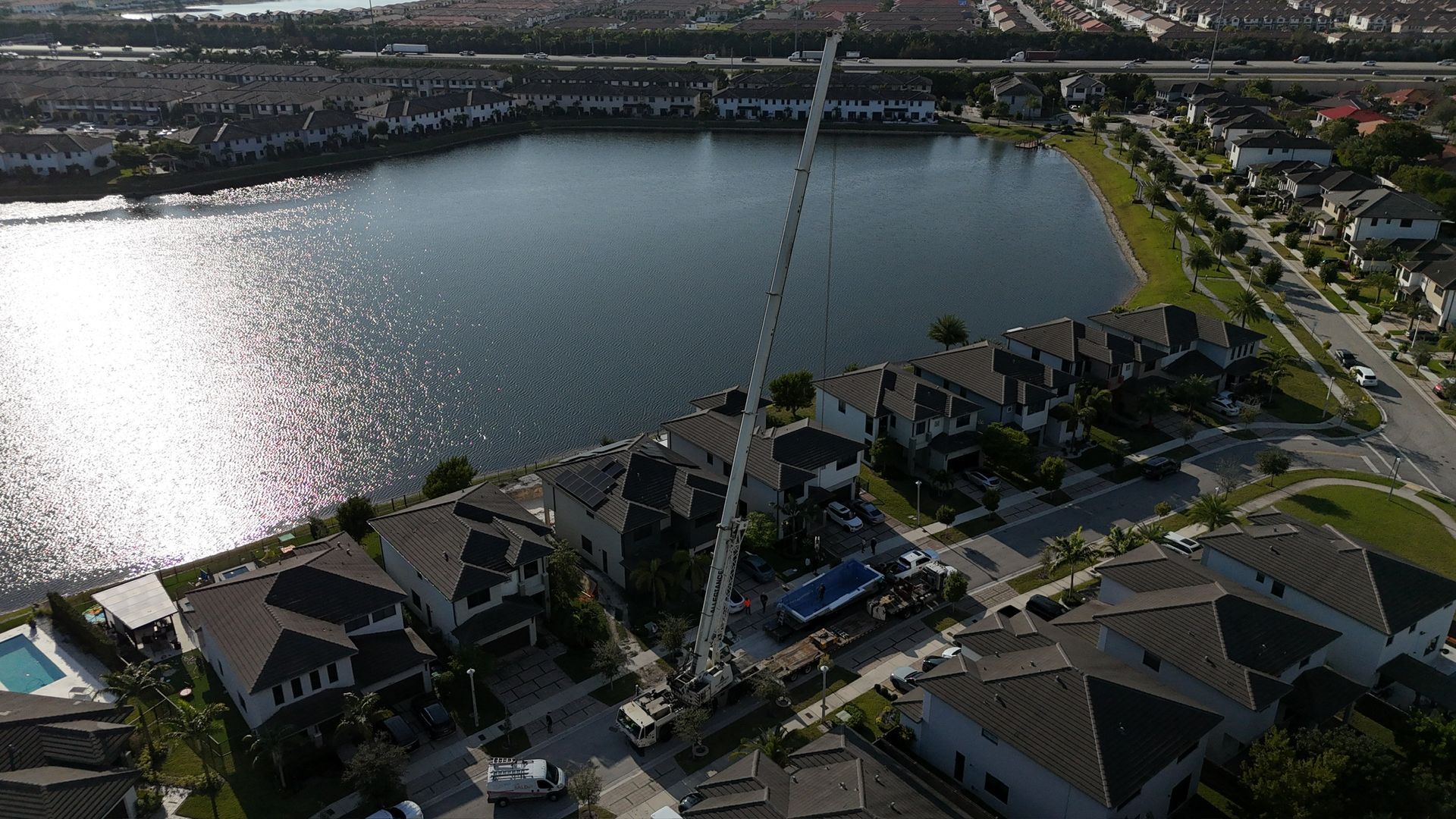 An aerial view of a residential area with a large body of water in the background.