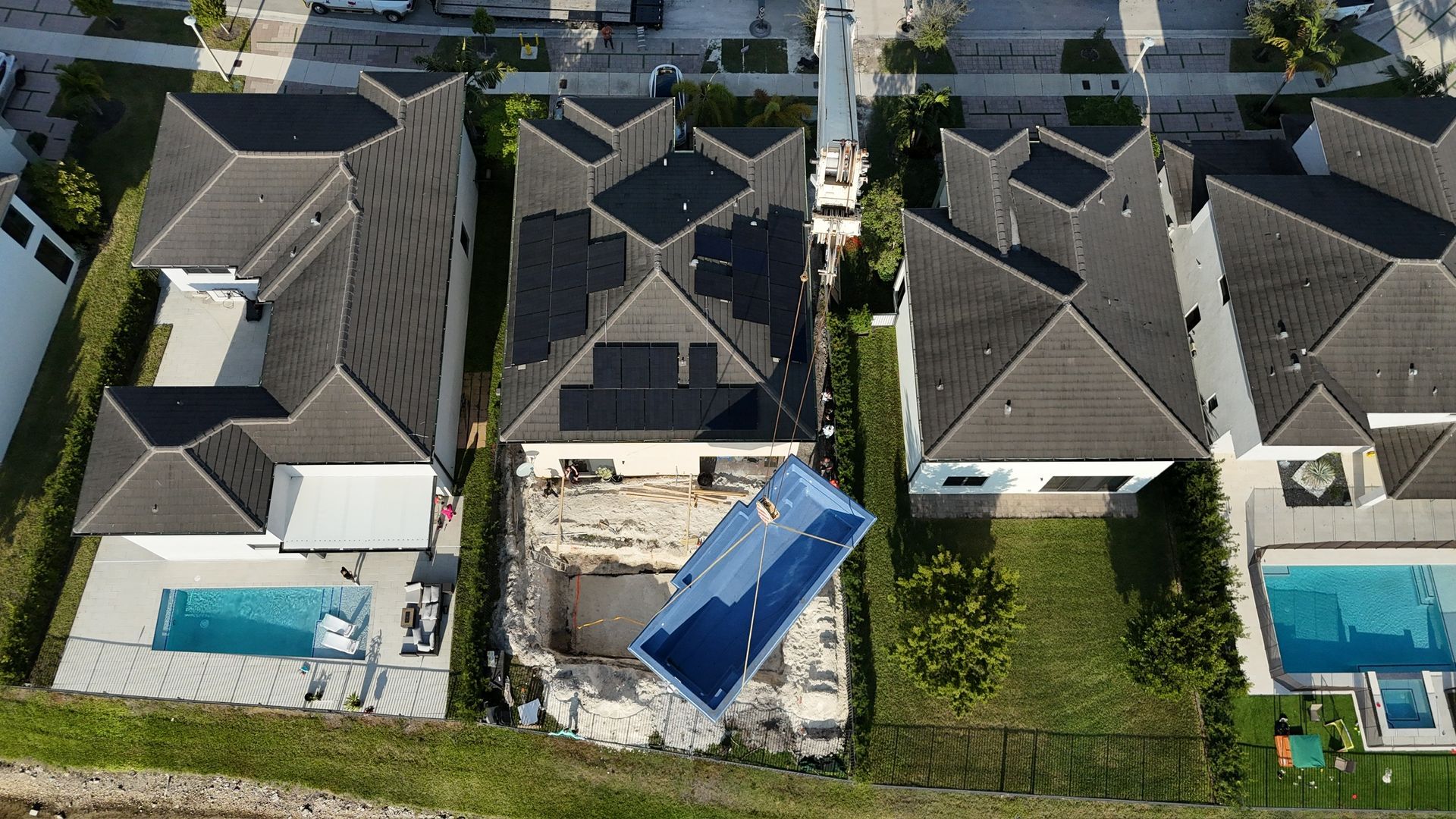 An aerial view of a residential area with houses and pools