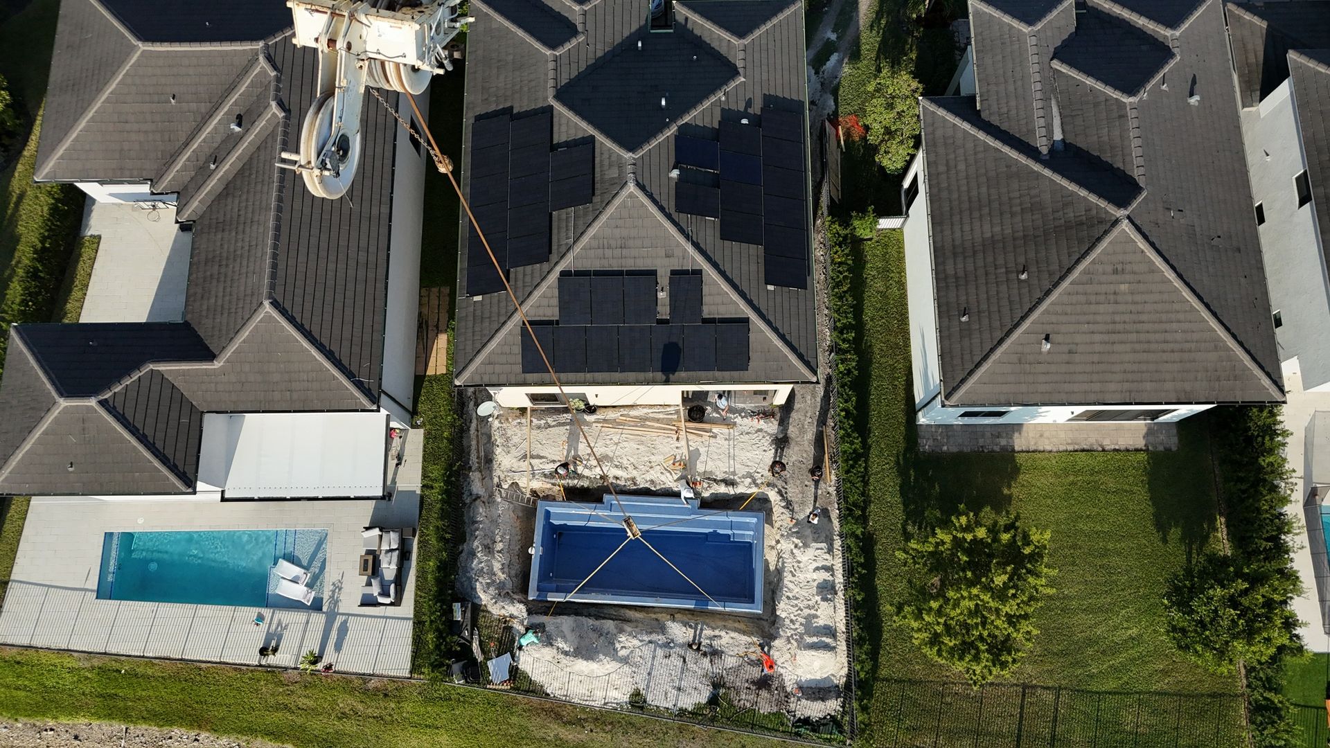 An aerial view of a house with a pool and solar panels on the roof.