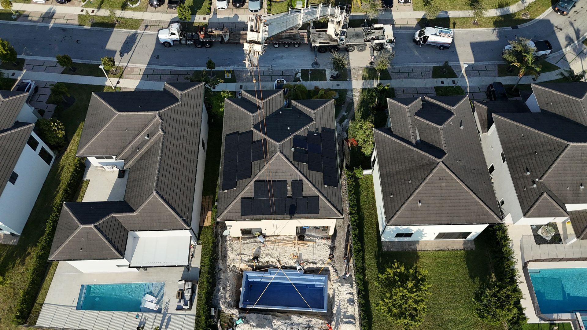 An aerial view of a residential area with houses and a pool.