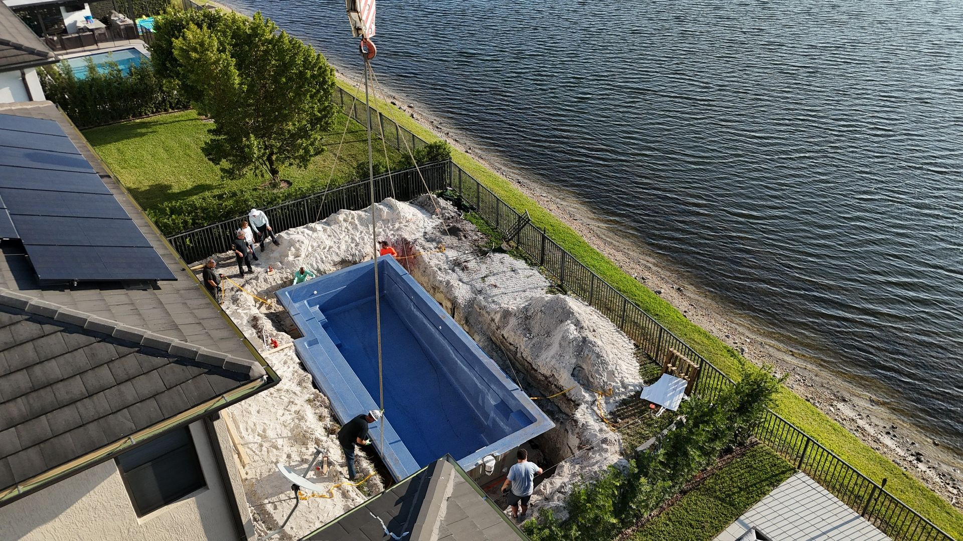 An aerial view of a swimming pool being built next to a body of water.
