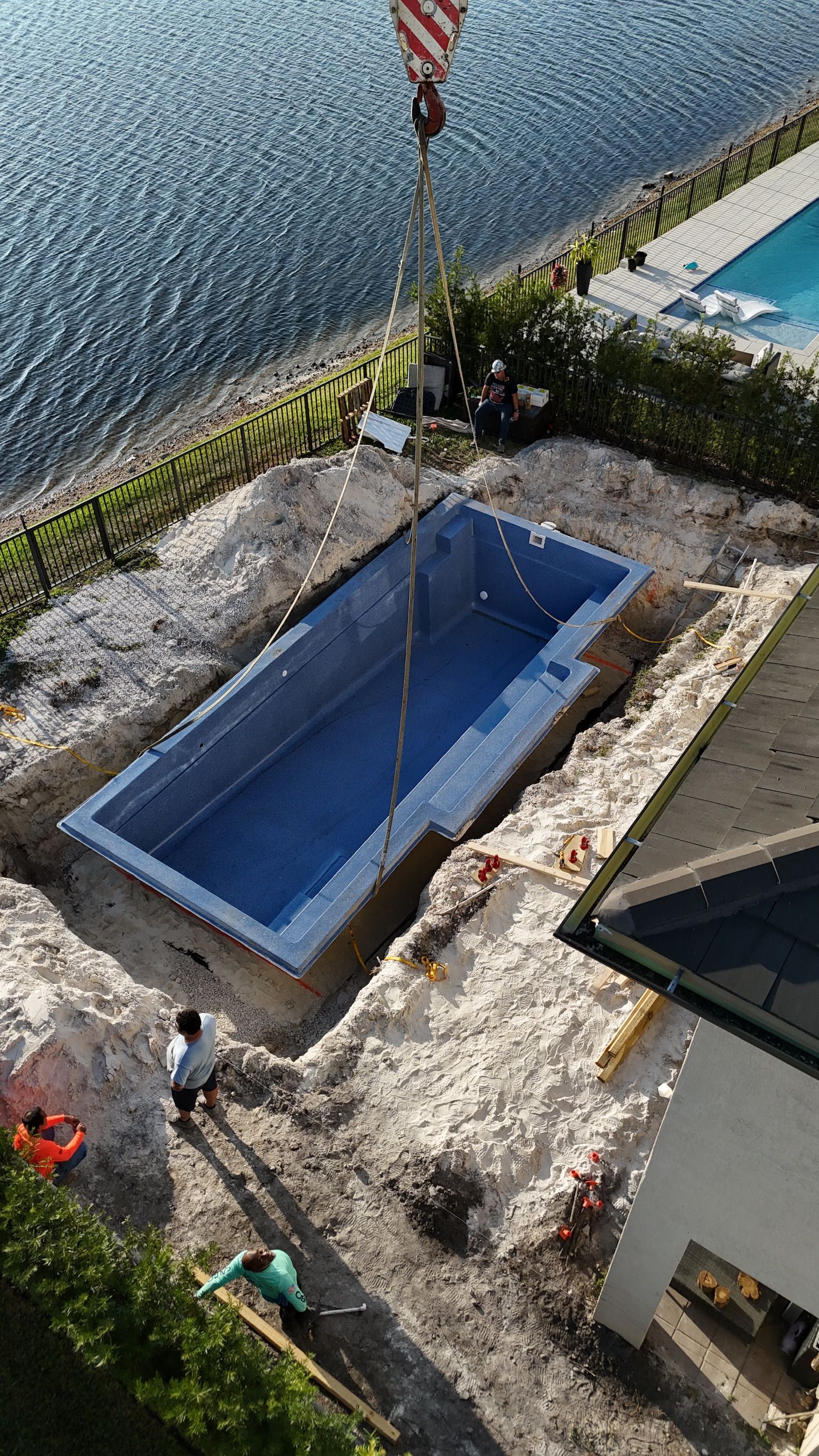 An aerial view of a swimming pool being built next to a body of water.