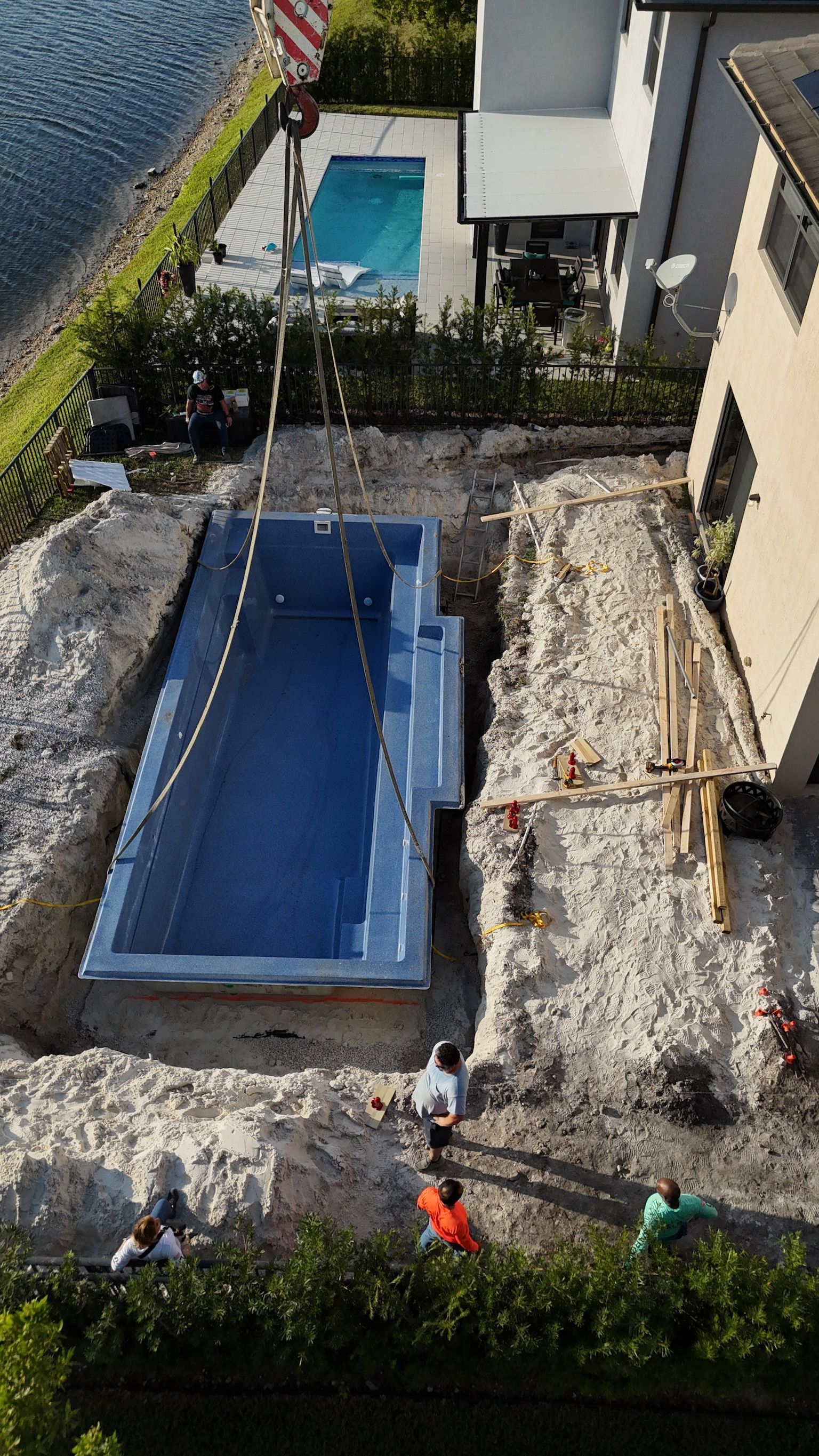 An aerial view of a swimming pool being built in a backyard.