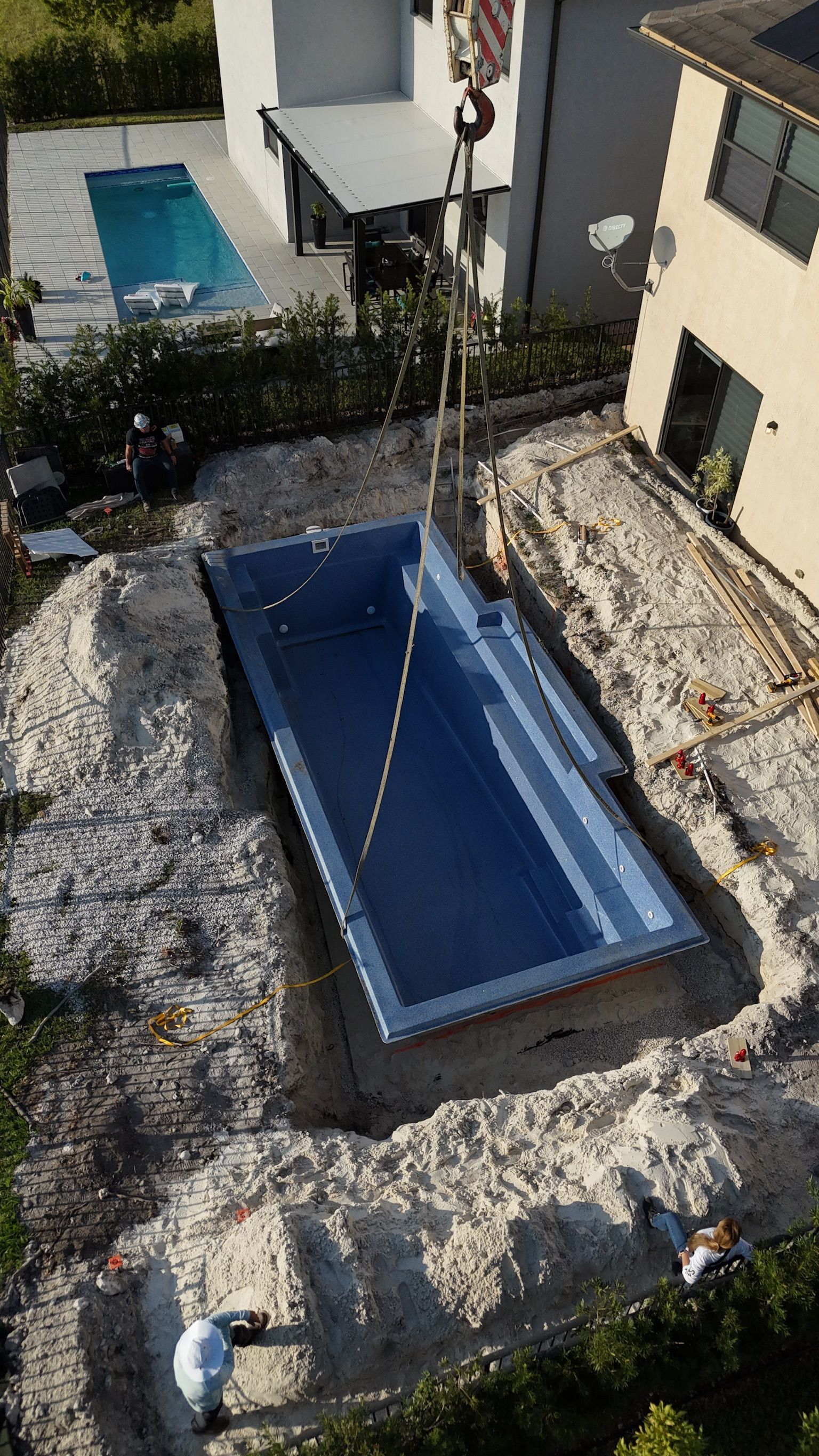 An aerial view of a swimming pool being built in a backyard.