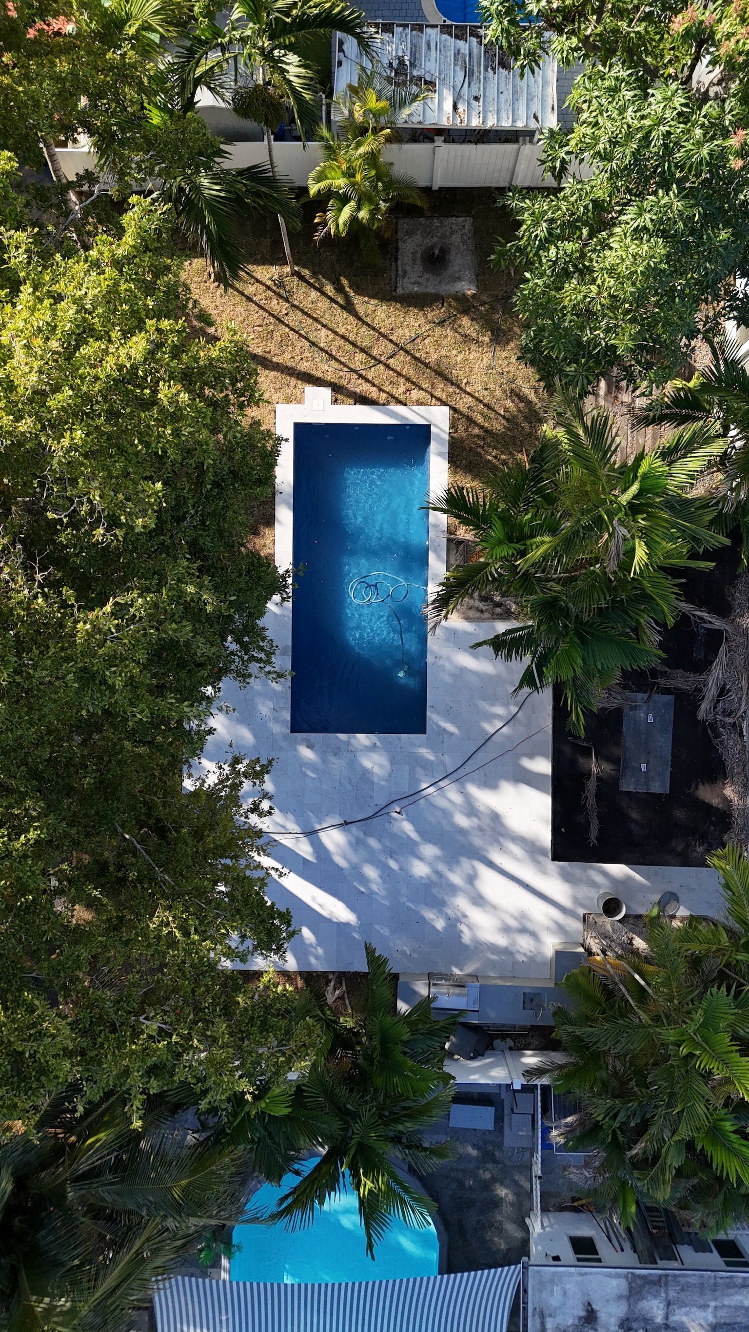 An aerial view of a large swimming pool surrounded by trees.