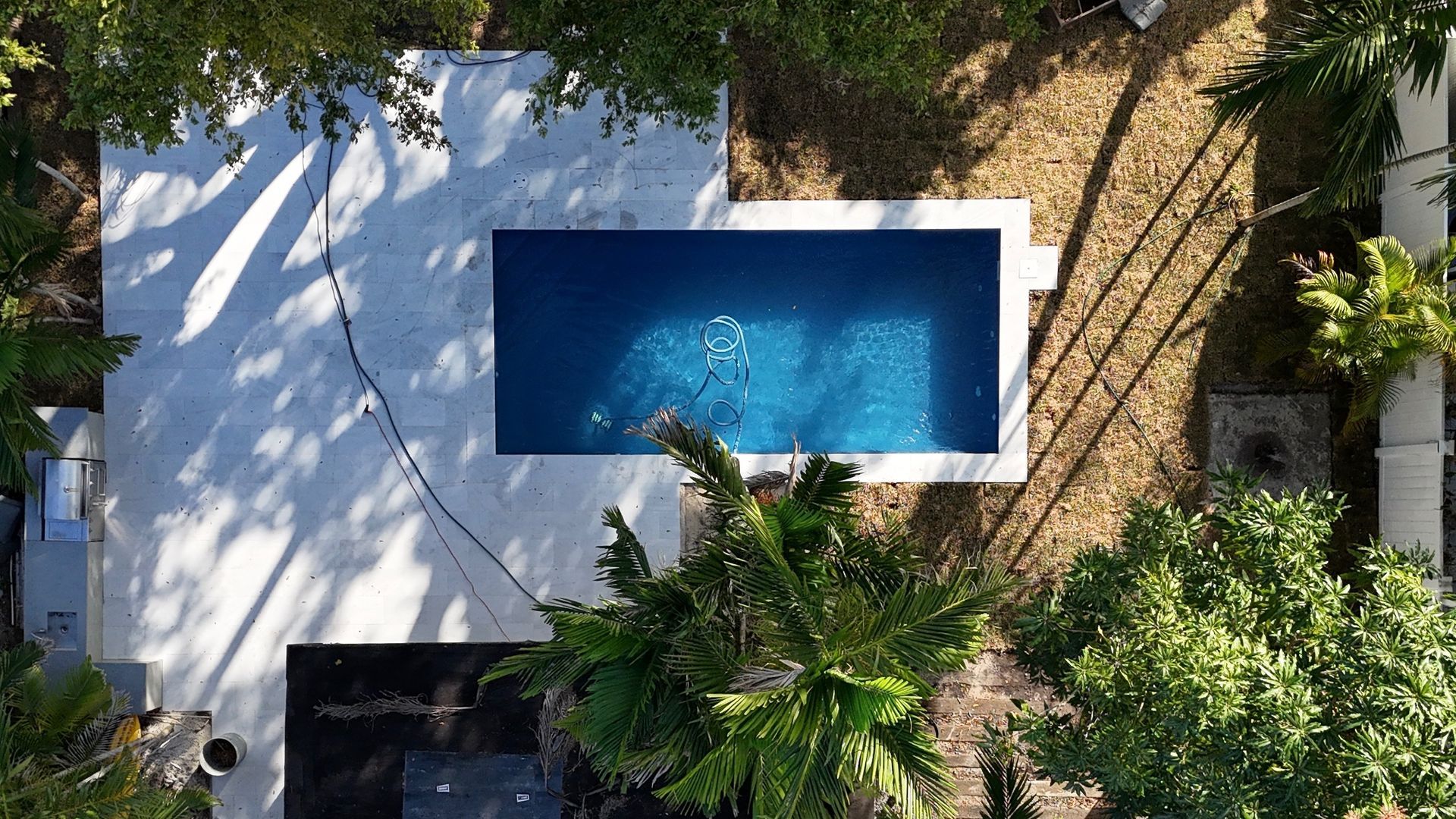 An aerial view of a large swimming pool surrounded by trees.
