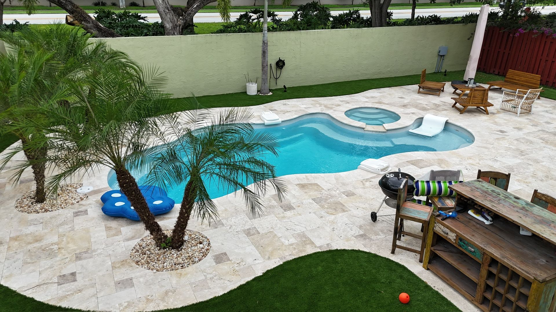 There is a large swimming pool in the middle of the backyard.